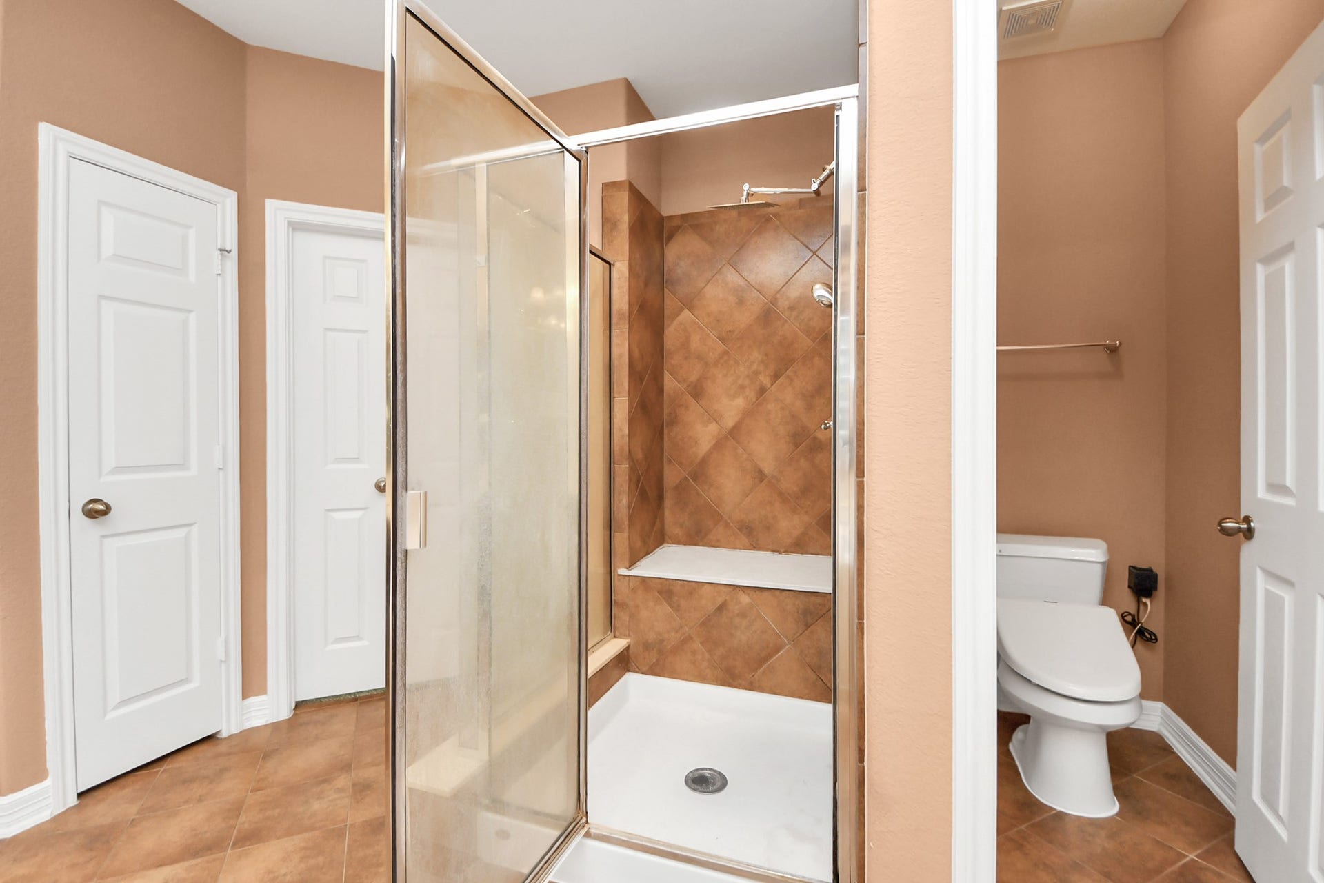 3003 Birch Landing Court, Pearland, TX 77584 A separate enclosed shower with a built-in bench sits alongside the private WC, ensuring both comfort and function.