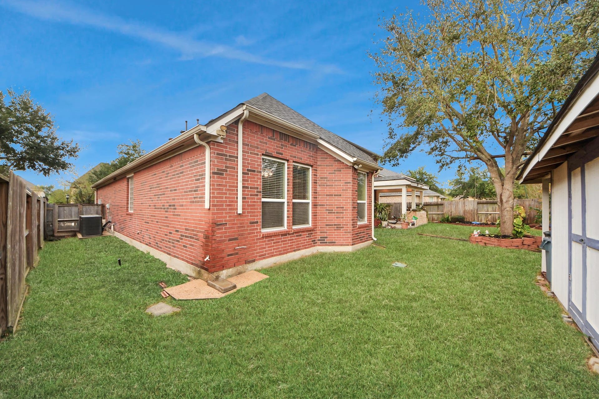 3003 Birch Landing Court, Pearland, TX 77584 The fenced backyard stretches wide with lush greenery, offering plenty of room for recreation or future enhancements.