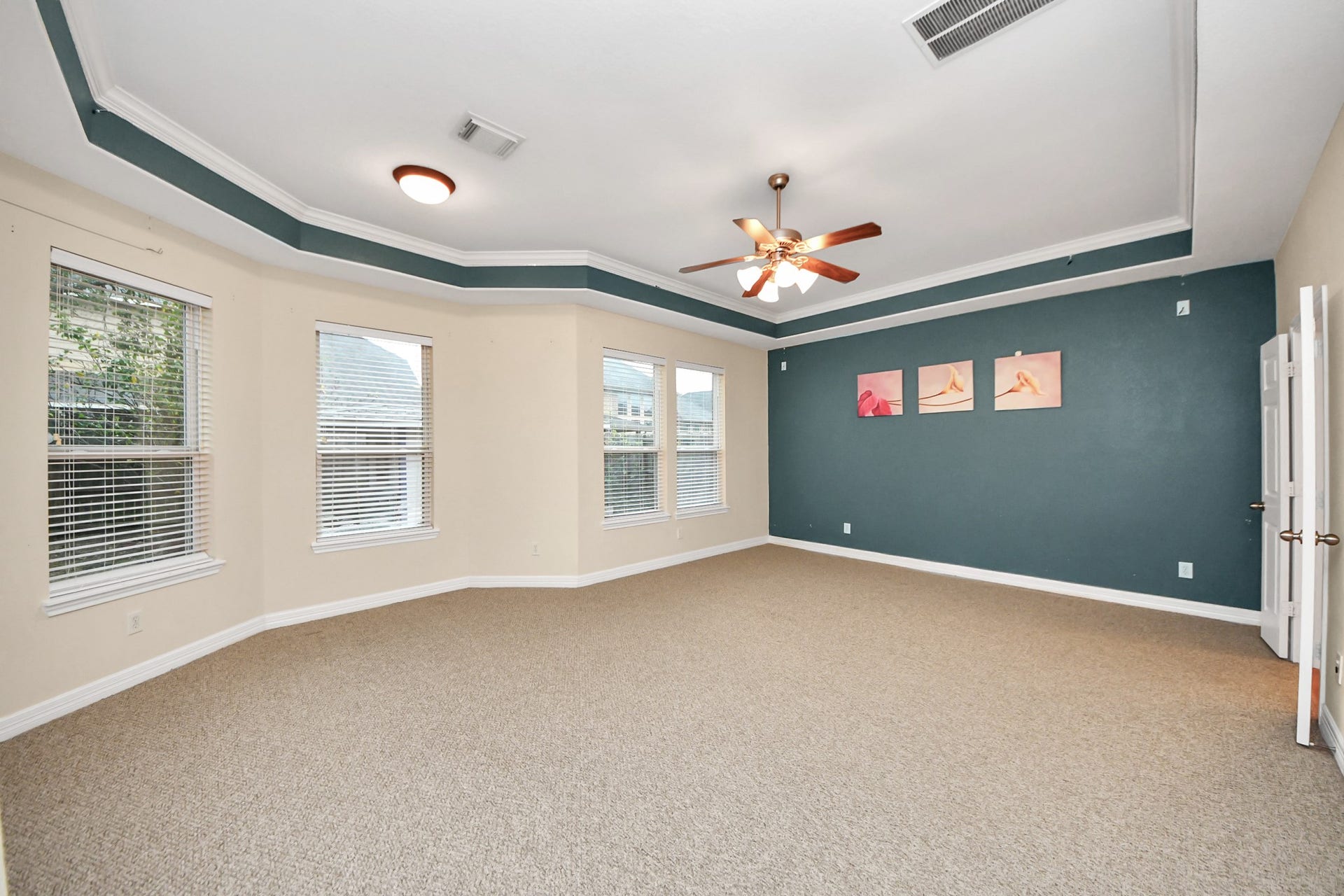 3003 Birch Landing Court, Pearland, TX 77584 The primary bedroom features generous dimensions, a decorative tray ceiling, soothing tones, and multiple windows.