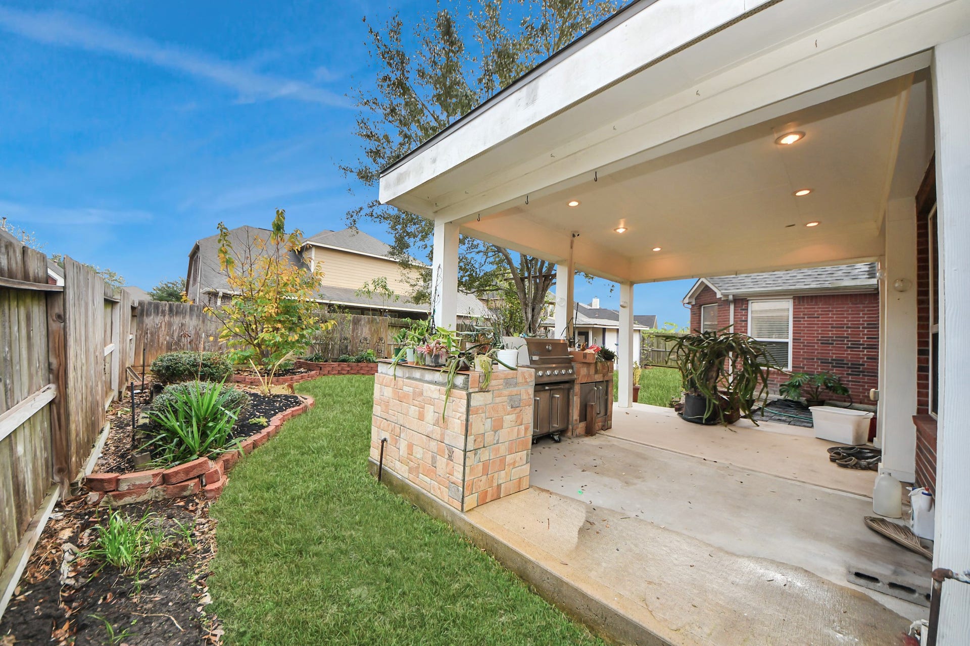 3003 Birch Landing Court, Pearland, TX 77584 The covered back patio creates a welcoming outdoor hub with a grill, recessed lighting, and lovely views of the landscaped yard.