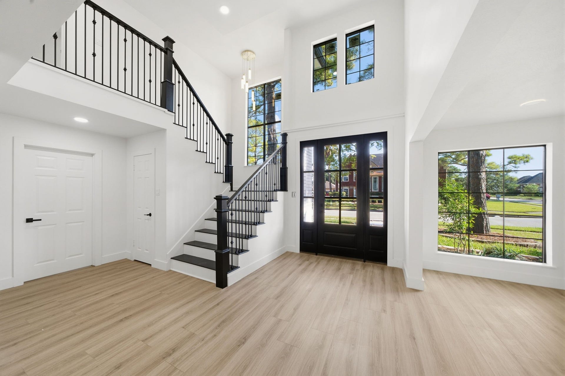 2304 Eagles Way, Pearland, TX 77581 Dramatic two-story foyer framed by new black Low-E windows and statement lighting.