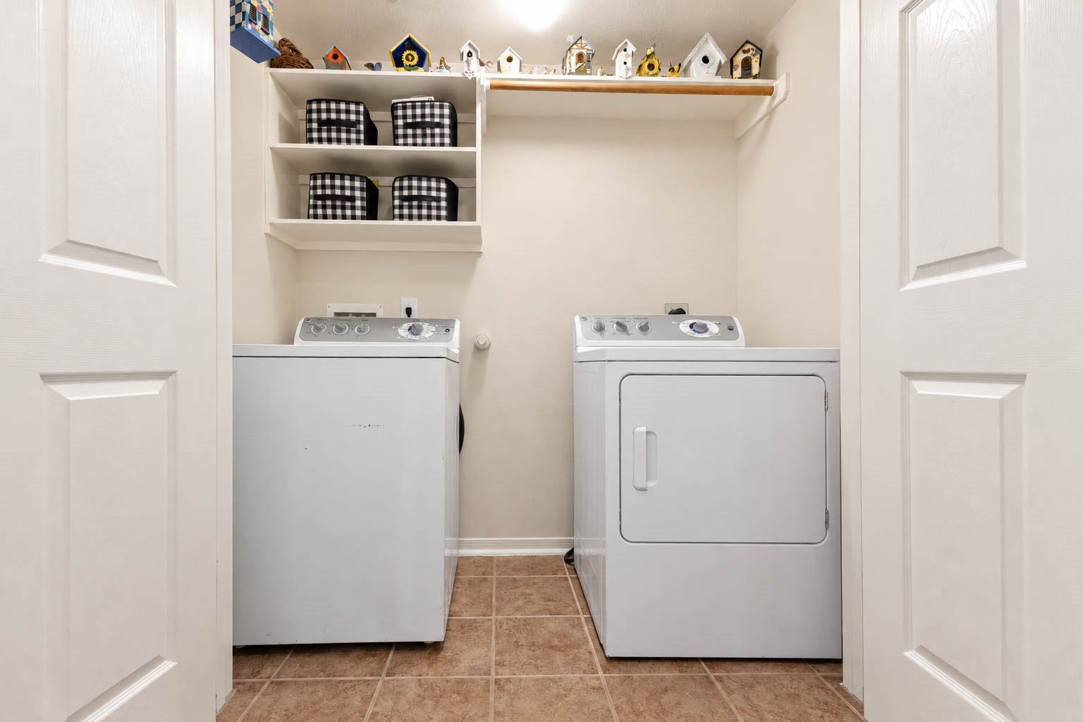 2532 Oak Dale Way, Seabrook, TX 77586 This laundry room is set up for convenience, with connections for a full size washer and dryer, tile flooring, and built in shelving with a hanging rod for freshly pressed clothes. Double doors close it off neatly from the rest of the home.