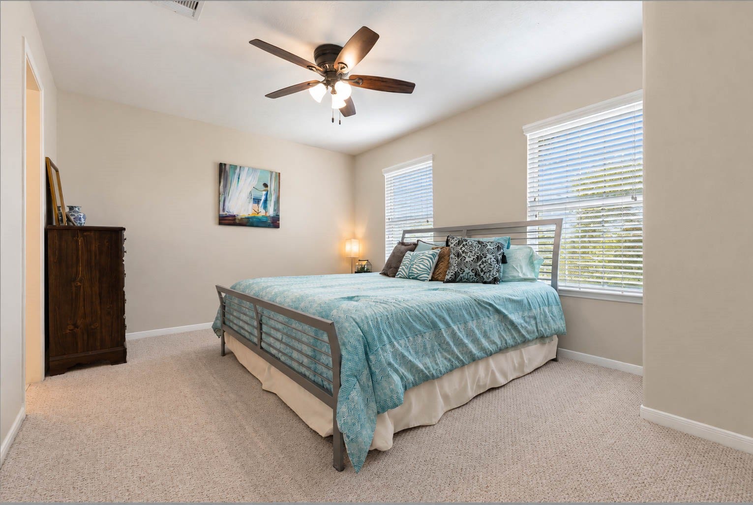 2532 Oak Dale Way, Seabrook, TX 77586 The first of the guest bedrooms features designer carpet underfoot, a warm and understated wall color, and two windows that give the room a cheerful, open feel. A ceiling fan keeps the air moving, and there is comfortable space for a king size bed with additional furniture.