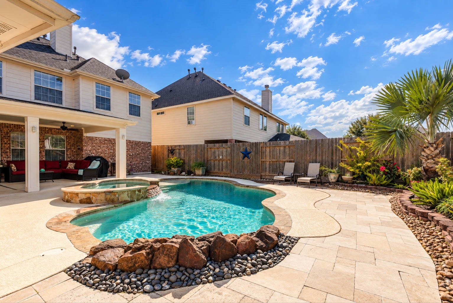 2532 Oak Dale Way, Seabrook, TX 77586 Thoughtful design shows in every corner of this backyard, from the pale paver decking and sculpted boulder accents to smooth river rock beds and stacked block borders that frame the planting areas.