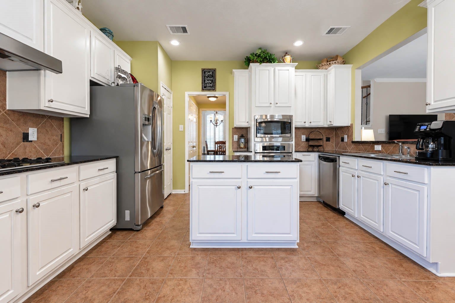 2532 Oak Dale Way, Seabrook, TX 77586 The heart of the home is this beautifully appointed kitchen, offering crisp white cabinetry, sleek dark countertops, and a center island with added storage. Stainless steel appliances, a gas cooktop, and a built-in oven and microwave make cooking a pleasure.