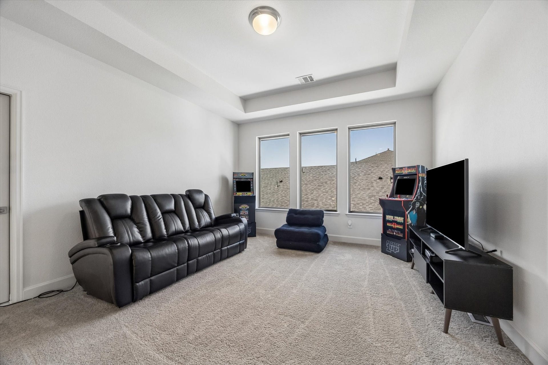 Spacious upstairs game room with tray ceiling, abundant natural light and endless possibilities for entertaining