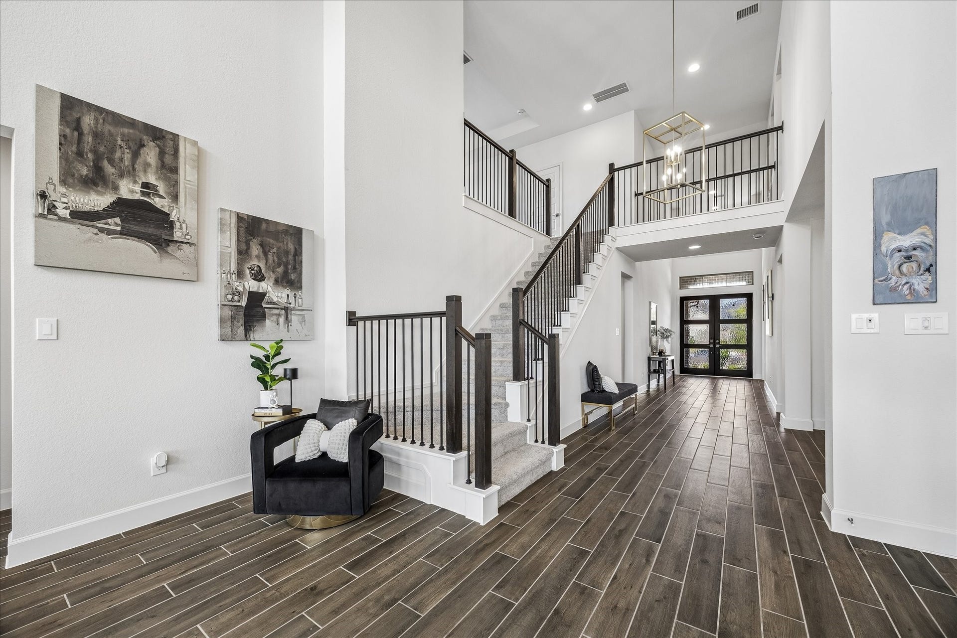 Grand two-story foyer featuring soaring ceilings, elegant staircase and beautiful wood-look tile flooring