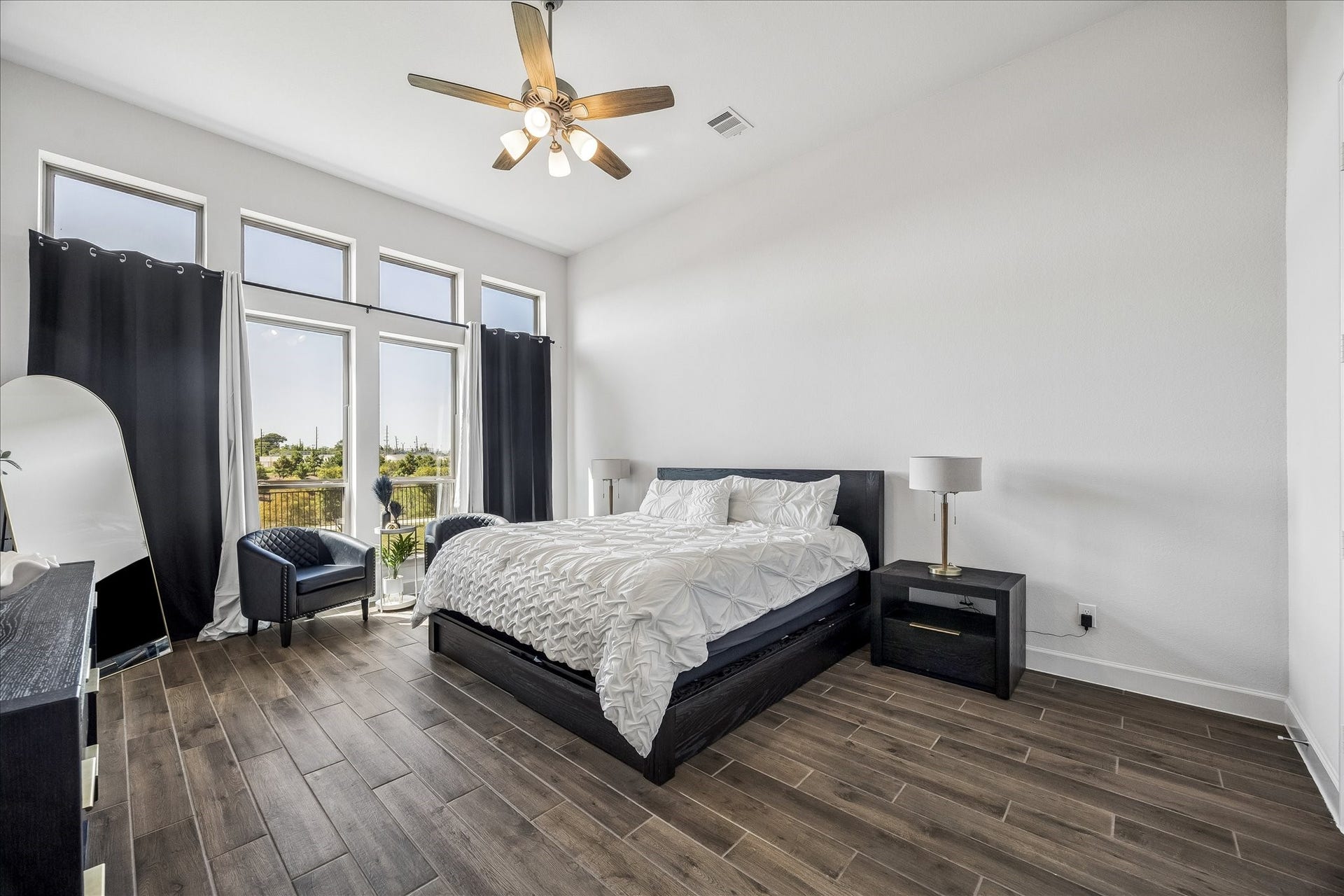 Spacious primary suite featuring soaring ceilings, expansive windows, and abundant natural light