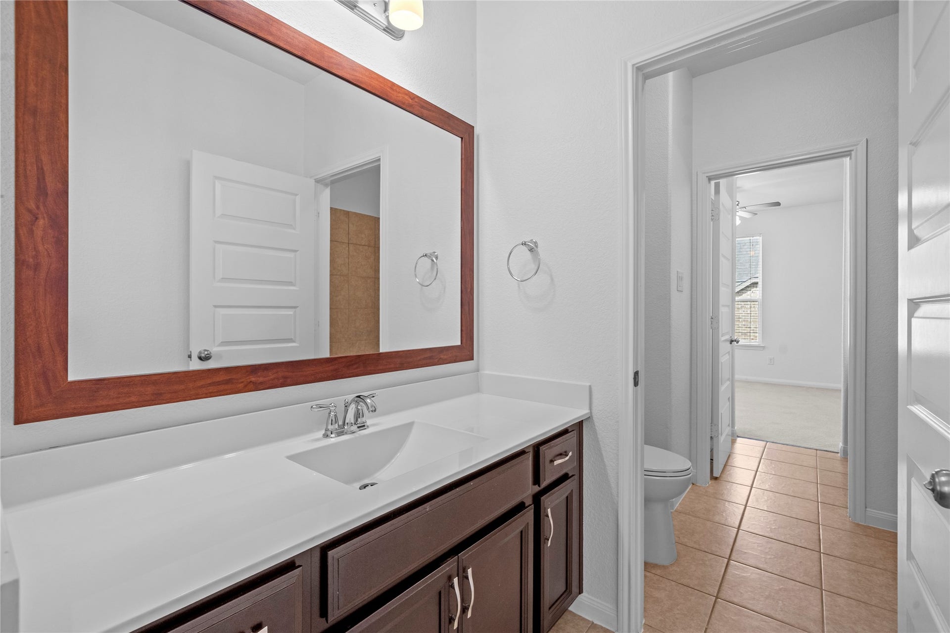 17315 Tomintoul Path, Richmond, TX 77407 Bathroom, highlighting the spacious vanity, large framed mirror, and convenient access between the secondary bedroom and bath.