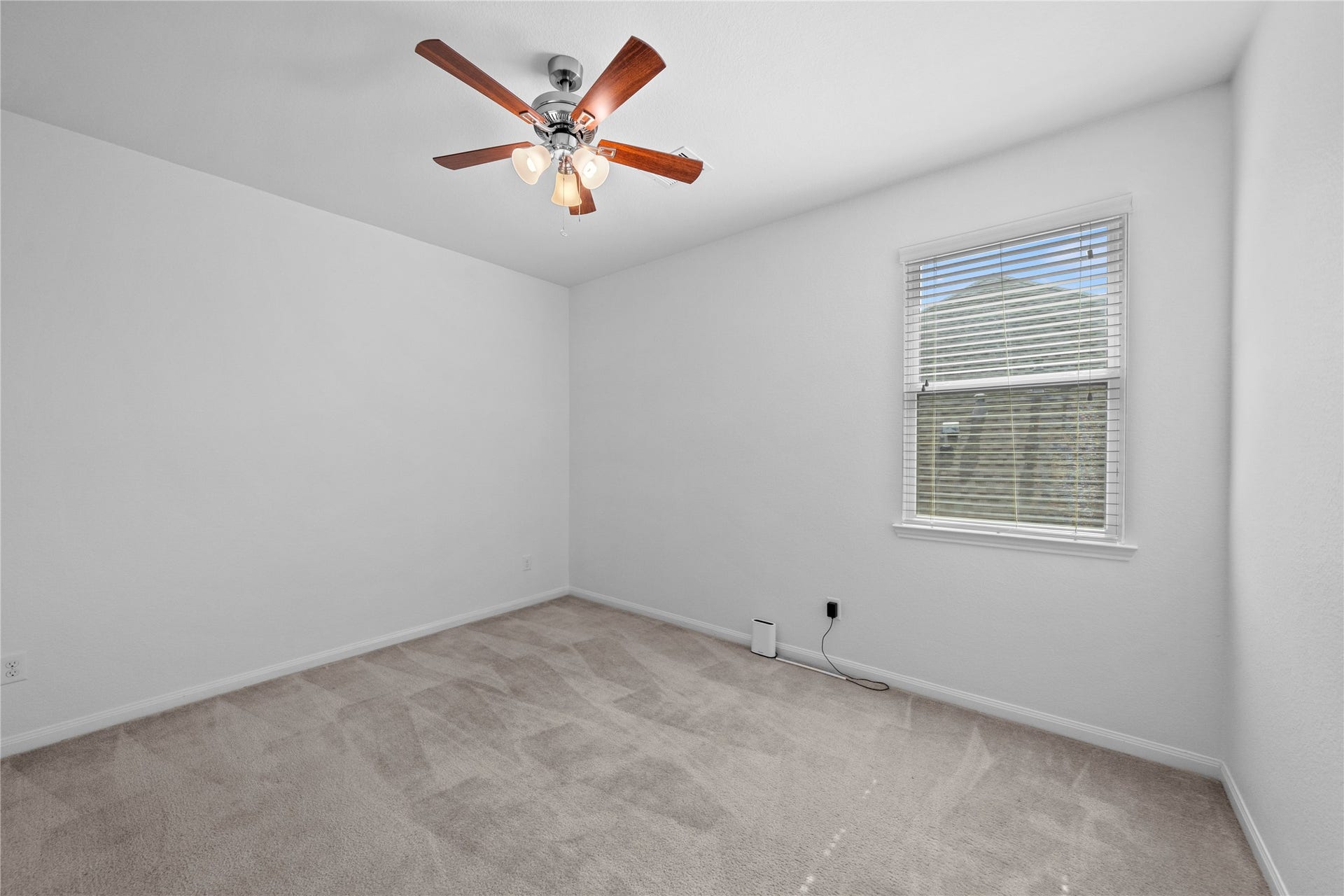 17315 Tomintoul Path, Richmond, TX 77407 Bright fourth bedroom featuring plush carpeting, a ceiling fan, and a large window that fills the space with natural light.