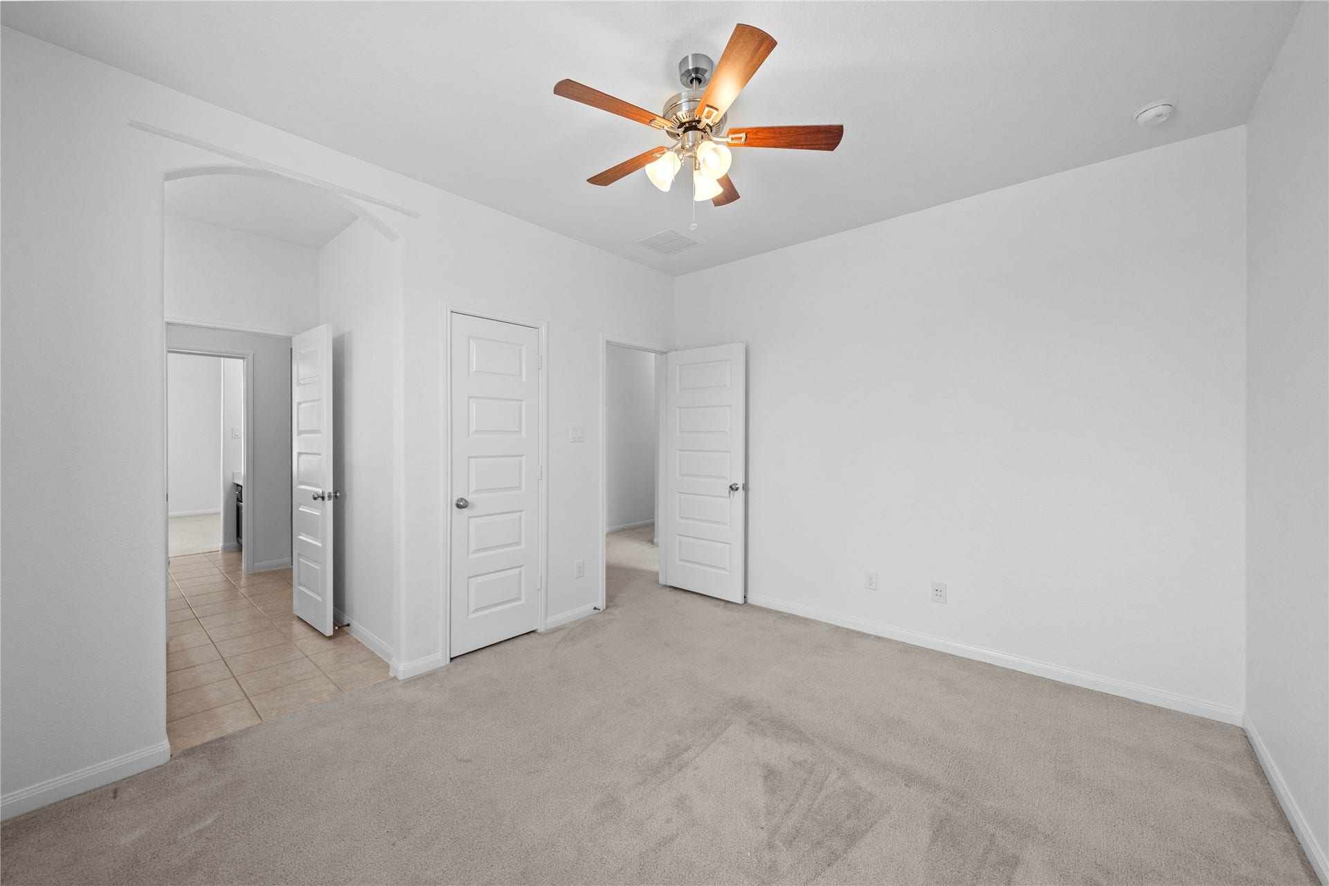 17315 Tomintoul Path, Richmond, TX 77407 Alternate view of the spacious third bedroom, highlighting the generous layout, plush carpeting, ceiling fan, and convenient access to the adjoining bath and closet areas.