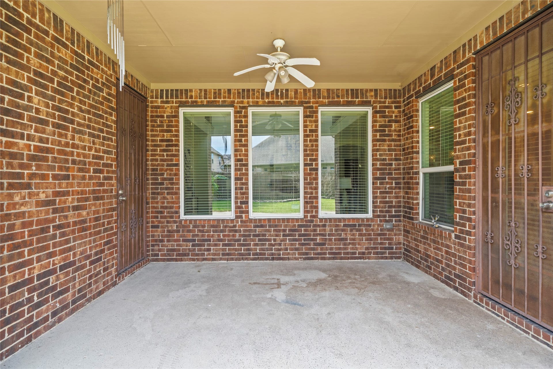 17315 Tomintoul Path, Richmond, TX 77407 Covered patio offering a ceiling fan, brick surround, and ample space for outdoor seating and entertaining.