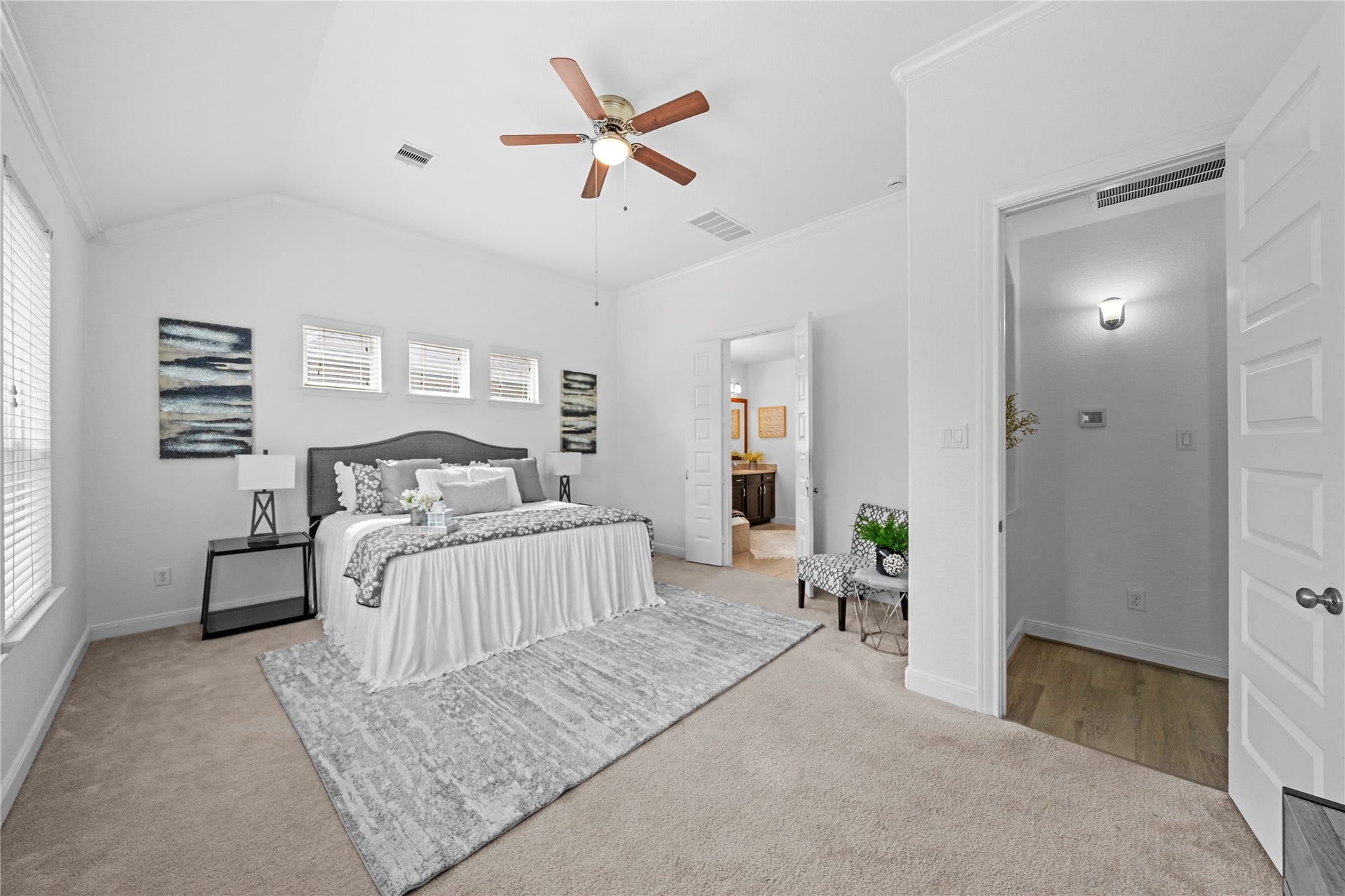 17315 Tomintoul Path, Richmond, TX 77407 A serene primary suite impresses with a soaring vaulted ceiling, abundant windows, plush carpeting, and direct access to the private en-suite bath.