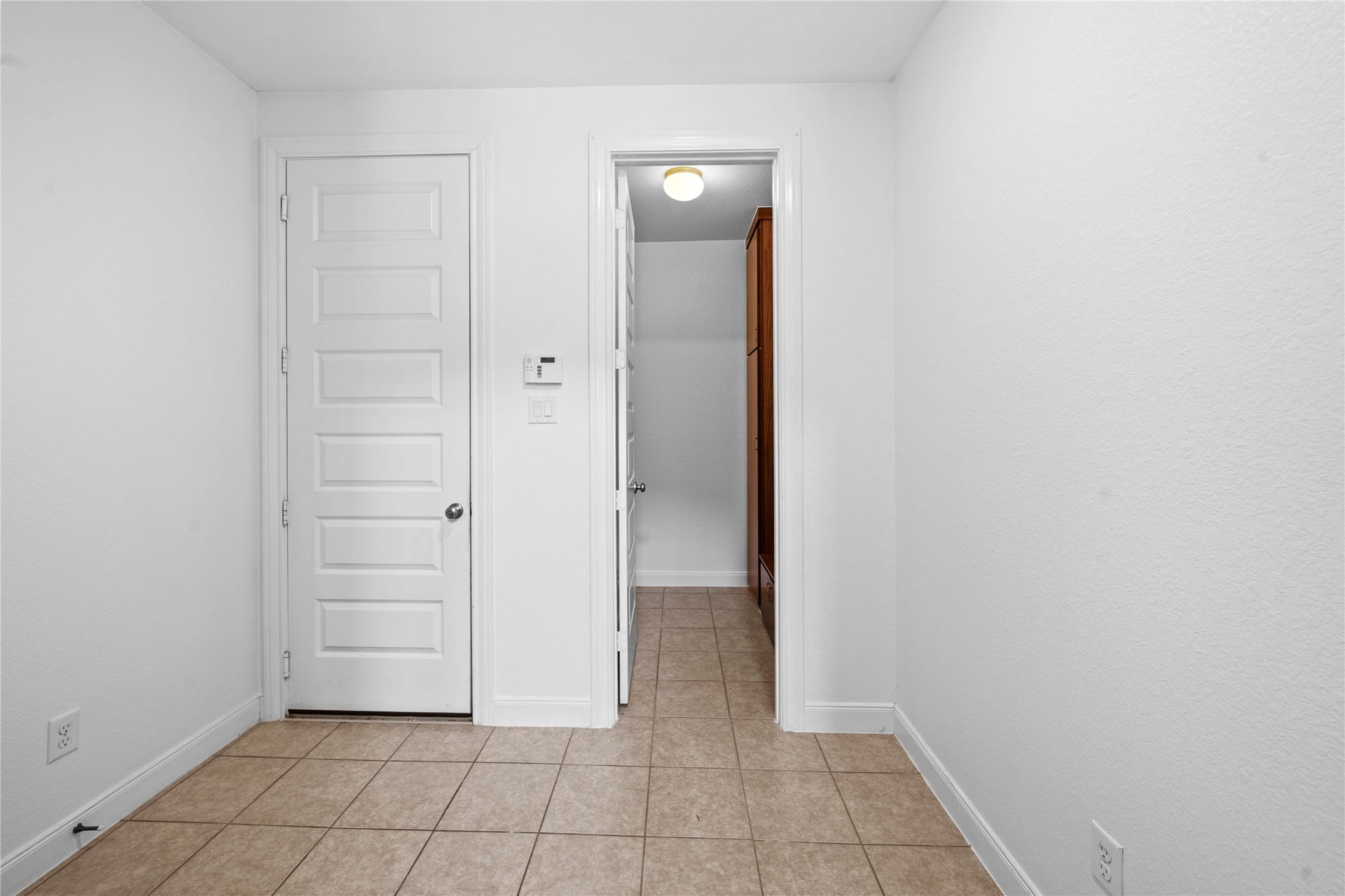 17315 Tomintoul Path, Richmond, TX 77407 A versatile tiled utility space offers a clean, practical layout with convenient access to additional built-in storage and the adjoining exterior entry.