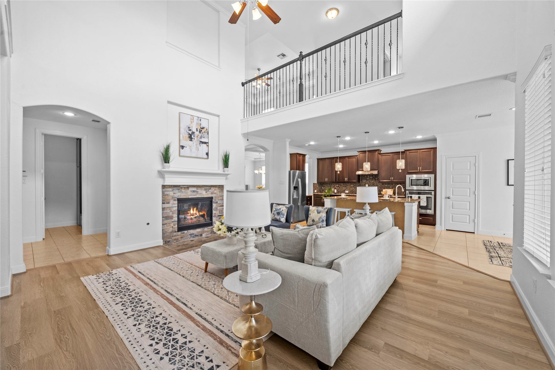 17315 Tomintoul Path, Richmond, TX 77407 An expansive open-concept design seamlessly unites the soaring family room and gourmet kitchen, enhanced by a fireside focal point and impressive upper-level overlook.