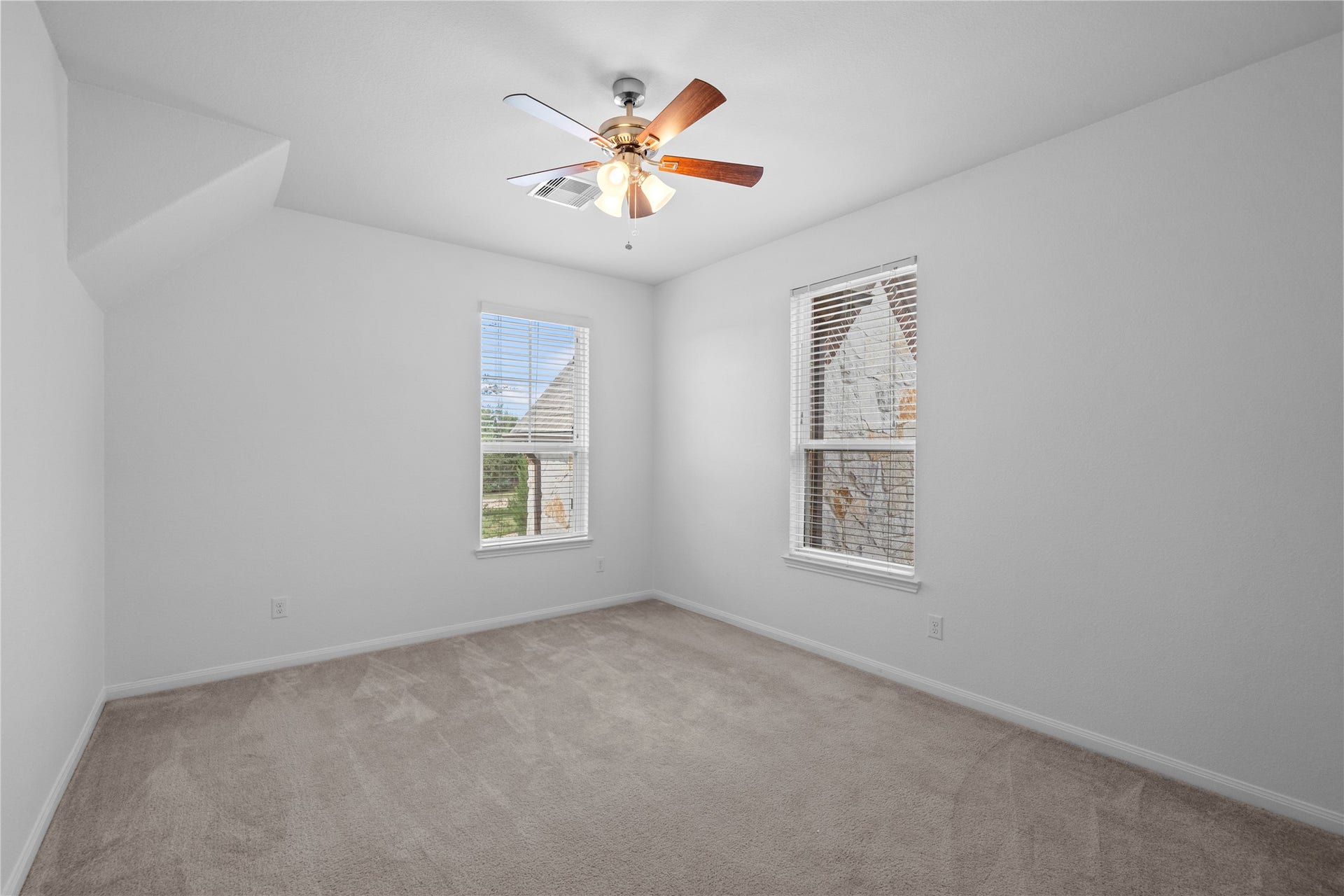 17315 Tomintoul Path, Richmond, TX 77407 Spacious secondary bedroom featuring plush carpeting, a ceiling fan, and multiple windows that fill the room with natural light.