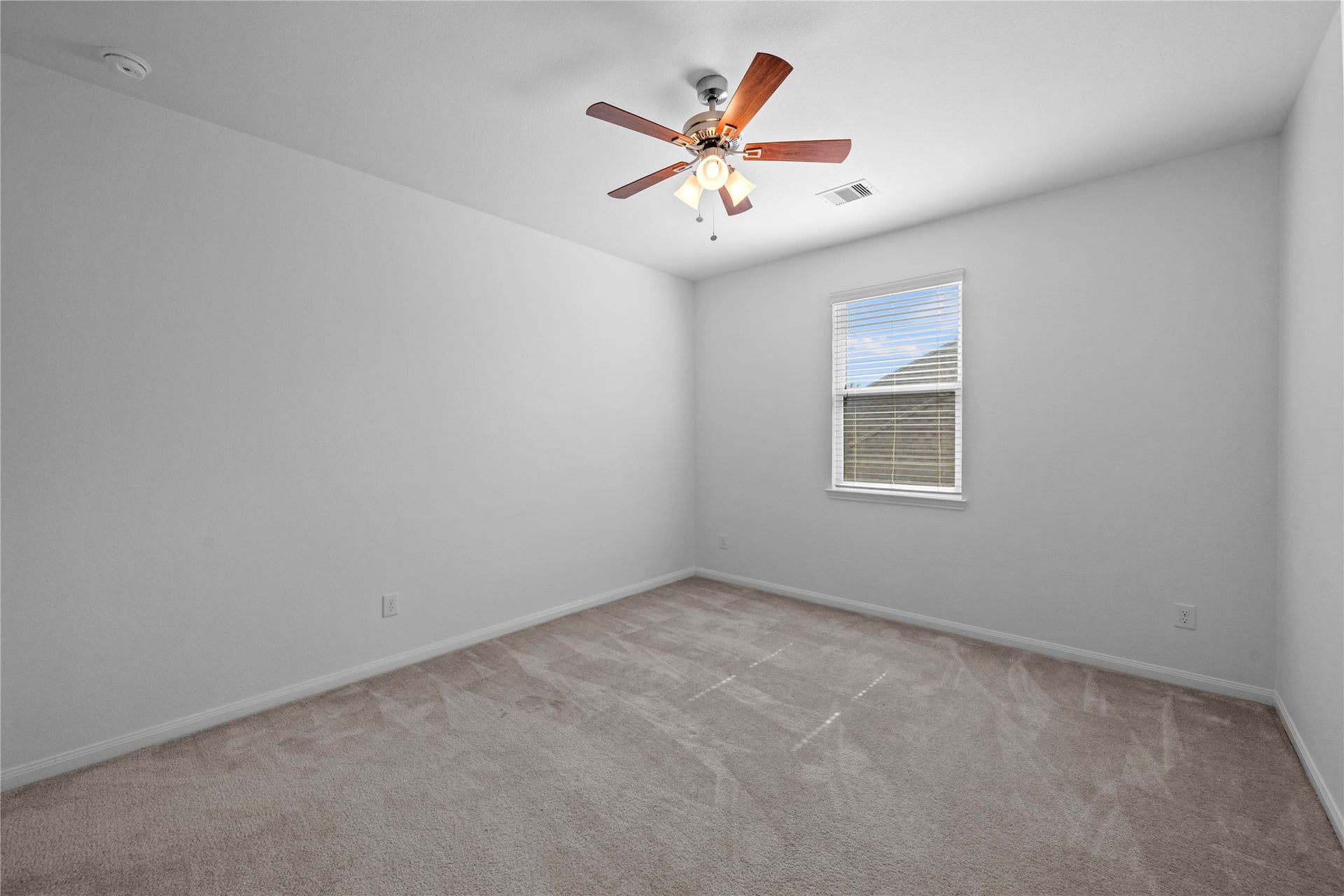17315 Tomintoul Path, Richmond, TX 77407 Spacious bedroom offering plush carpeting, a ceiling fan, and a large window providing abundant natural light.