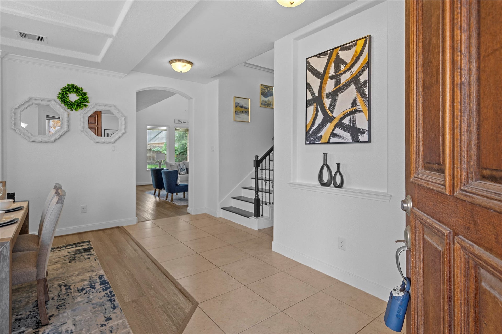 17315 Tomintoul Path, Richmond, TX 77407 A refined foyer welcomes guests with graceful architectural detailing, a tray ceiling, elegant staircase, and seamless sightlines into the beautifully appointed living spaces.