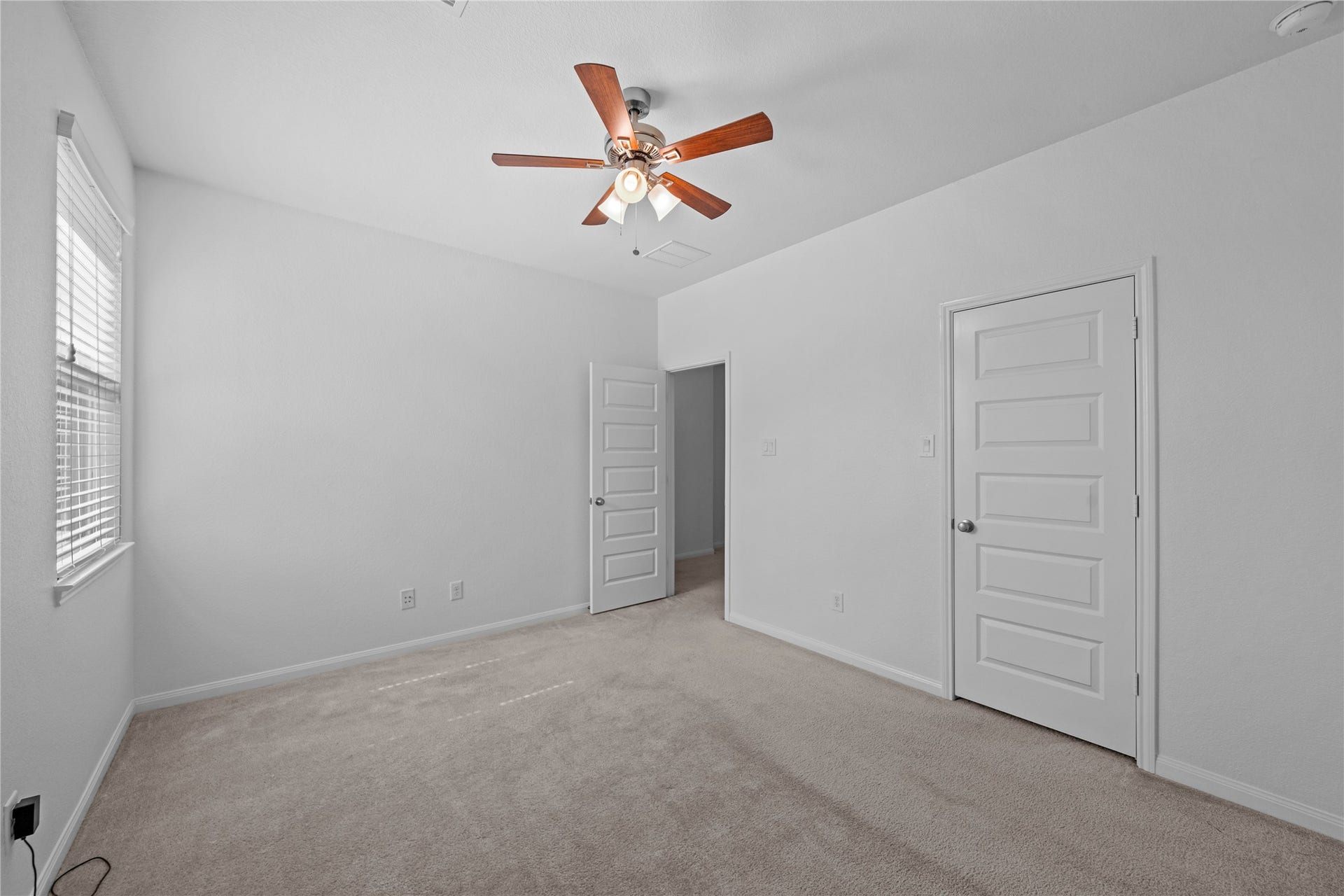 17315 Tomintoul Path, Richmond, TX 77407 Alternate view of the bedroom, showcasing its spacious layout, plush carpeting, ceiling fan, and ample closet storage.