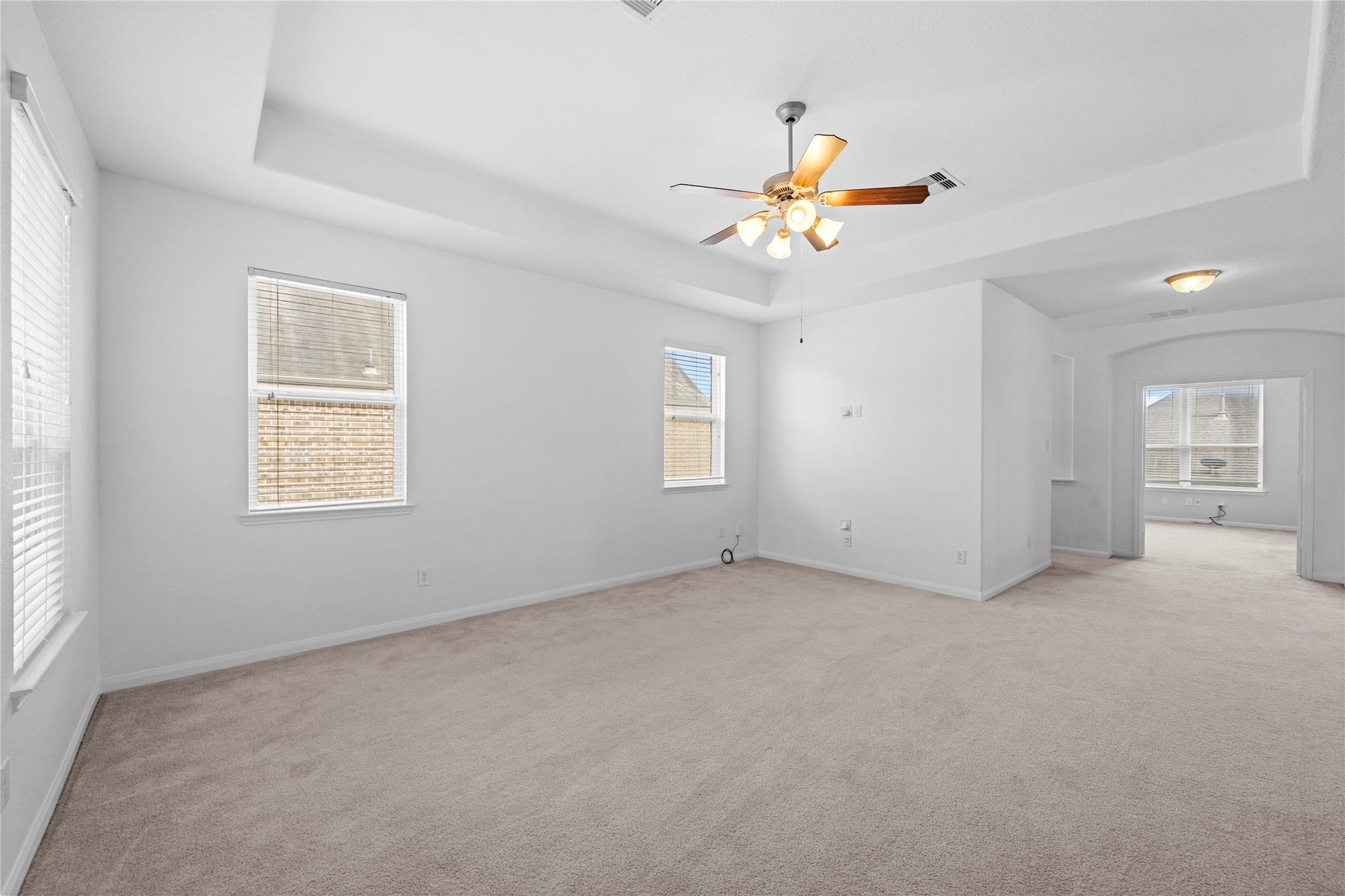 17315 Tomintoul Path, Richmond, TX 77407 Another view of the spacious upstairs game room, featuring abundant natural light, a tray ceiling, and flexible space for entertainment or relaxation.