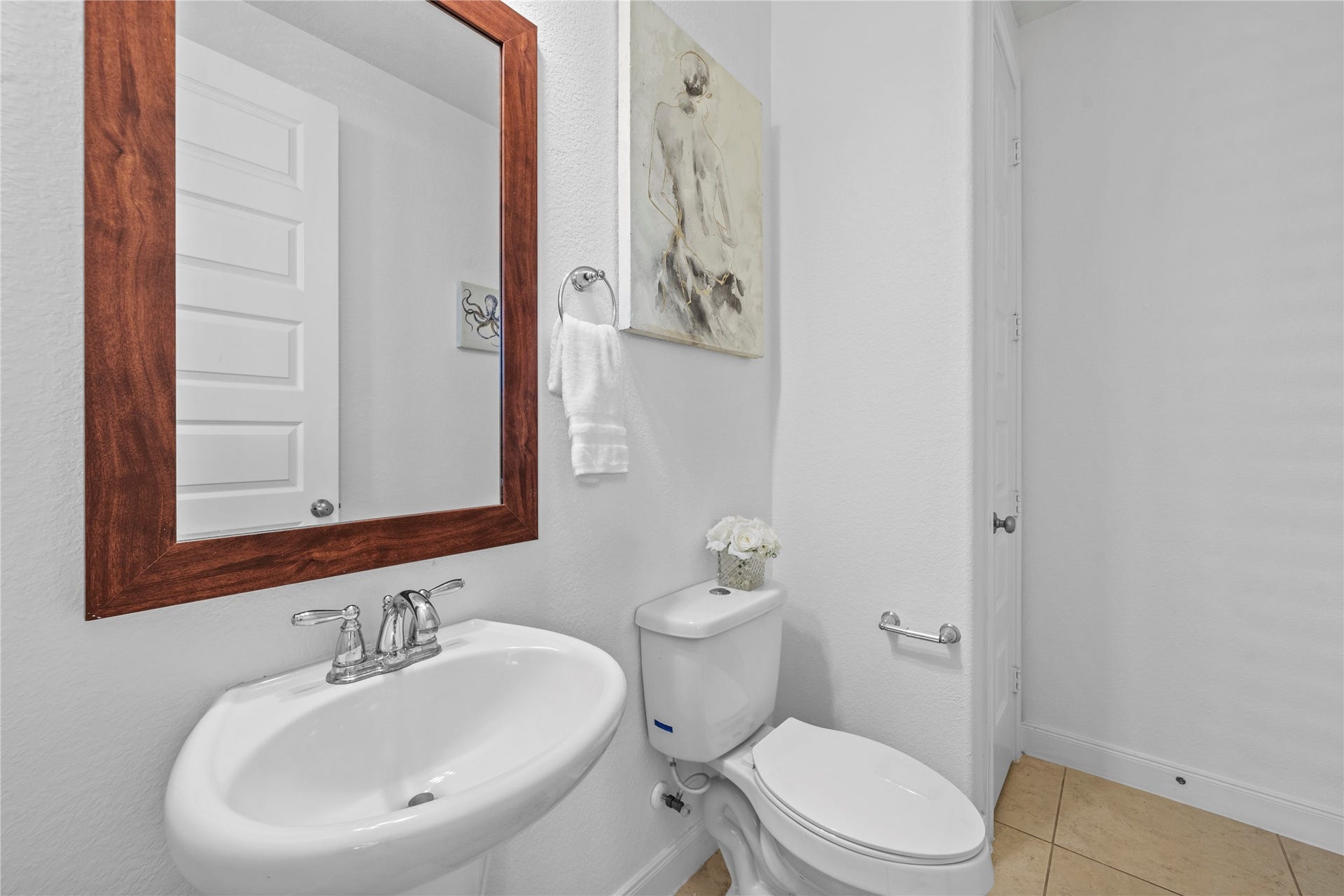 17315 Tomintoul Path, Richmond, TX 77407 Convenient half bath featuring a pedestal sink, framed mirror, and neutral finishes.
