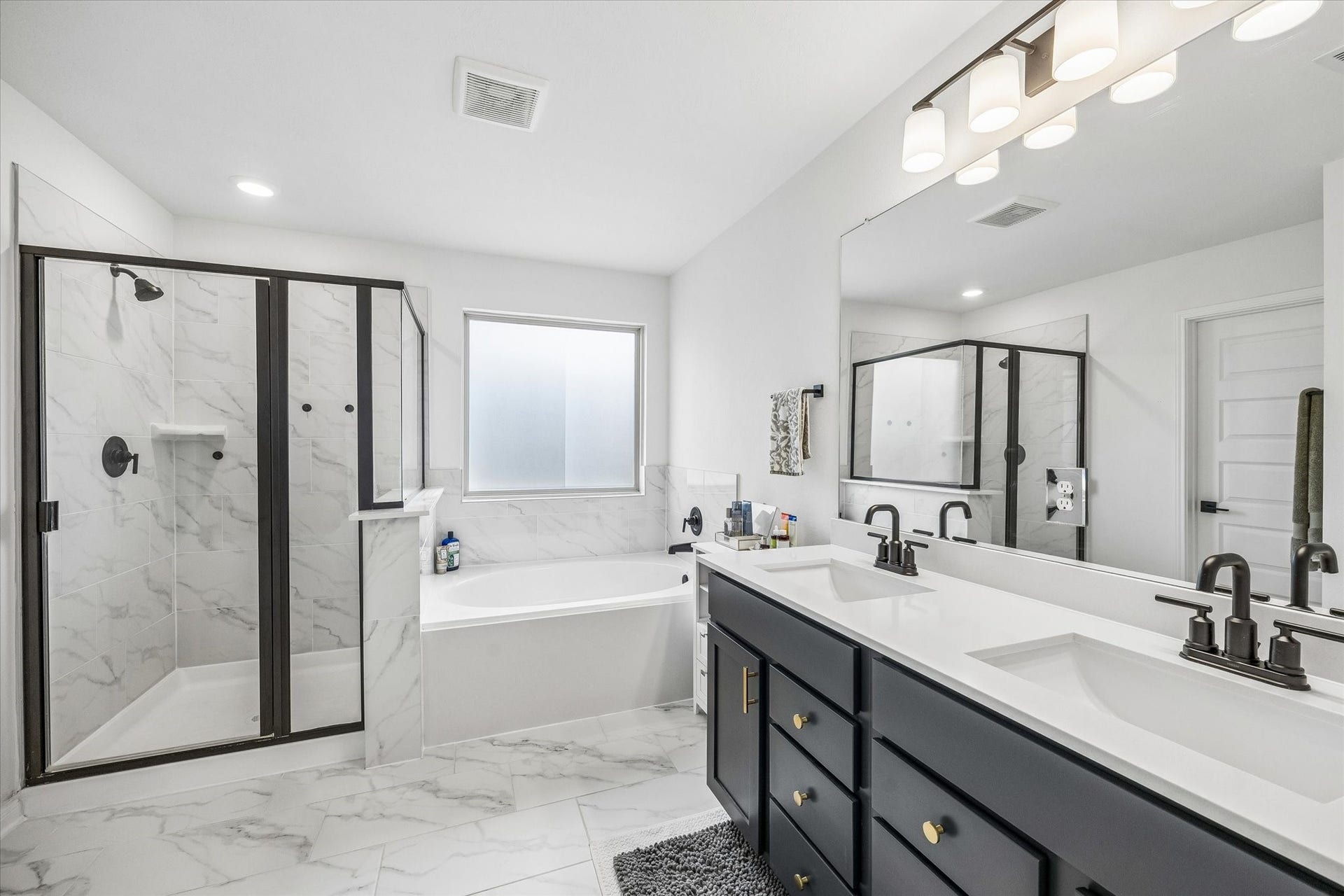 2852 Grand Anse Drive, Katy, TX 77493 Beautiful primary bath featuring a dual-sink vanity, soaking tub, separate glass-enclosed shower, and modern finishes.