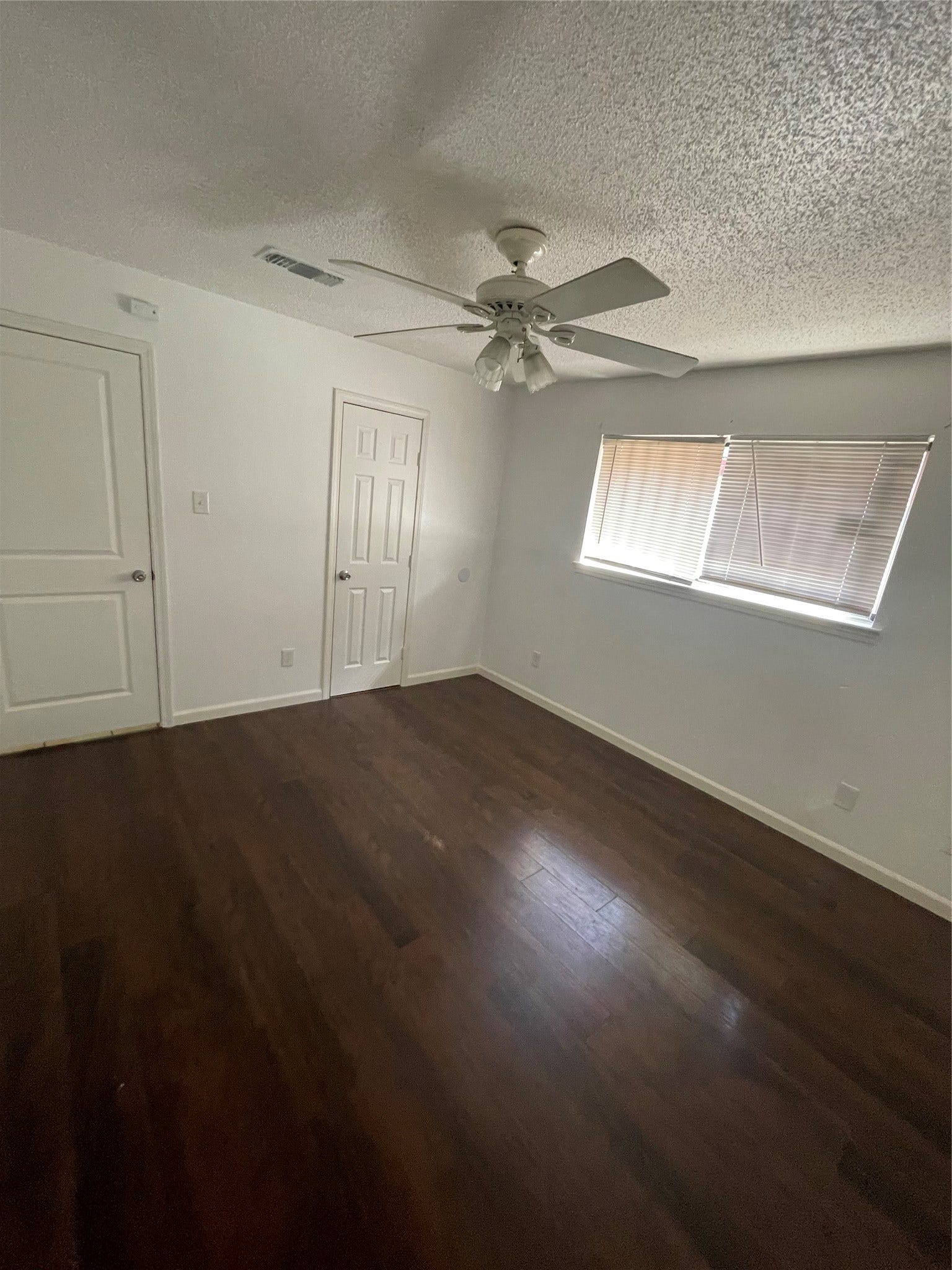 Another view of the spacious primary bedroom. This angle highlights the bedroom layout and access to the half bathroom, which connects to the full bathroom.