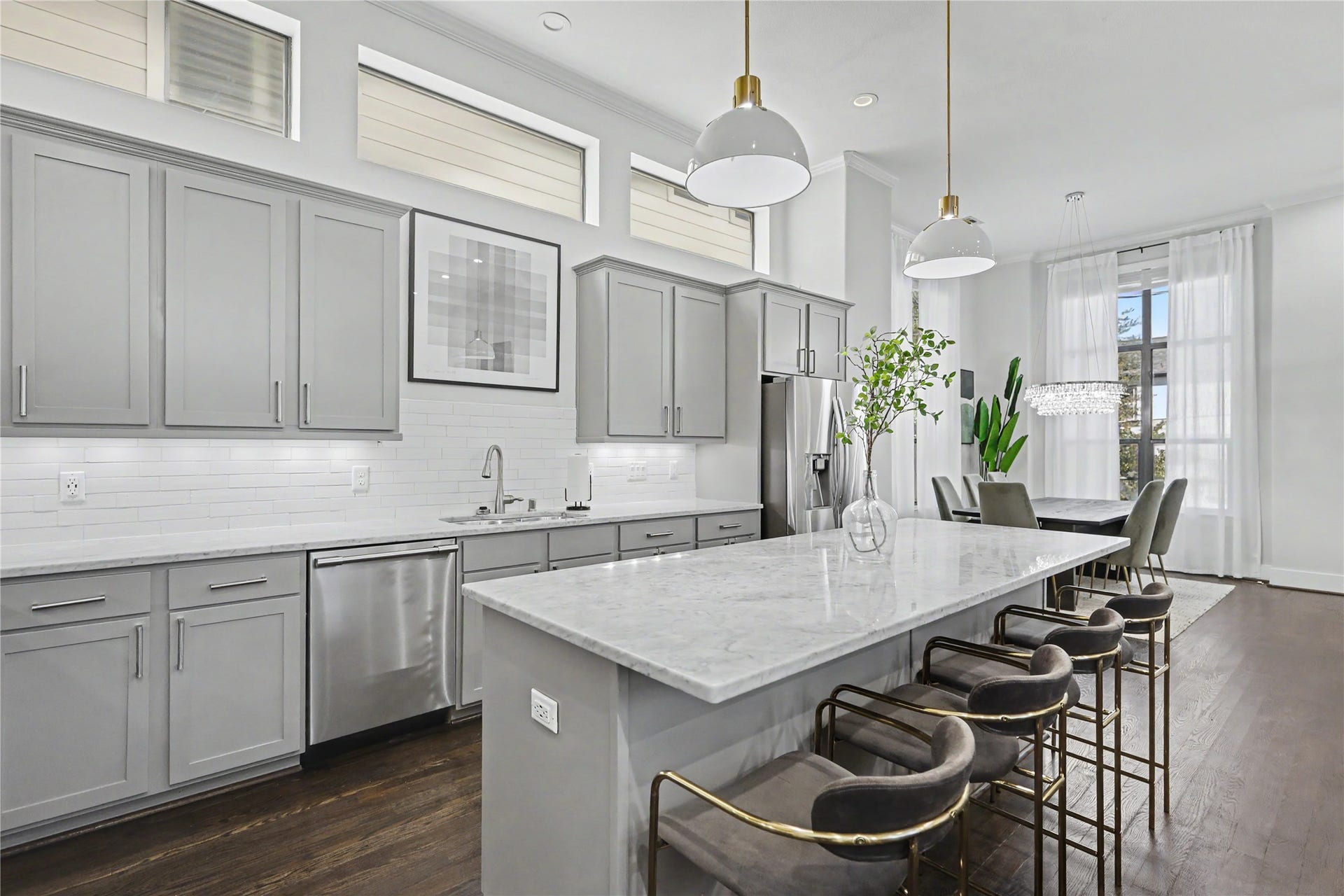 Notice designer pendant lighting over the marble island, which seats 4 comfortably.