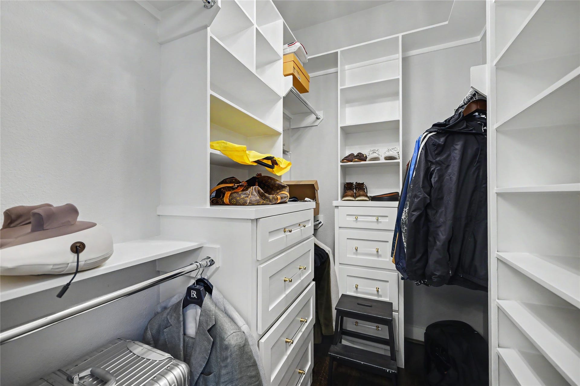 Second walk-in closet for the primary bedroom, also featuring built-in drawers.