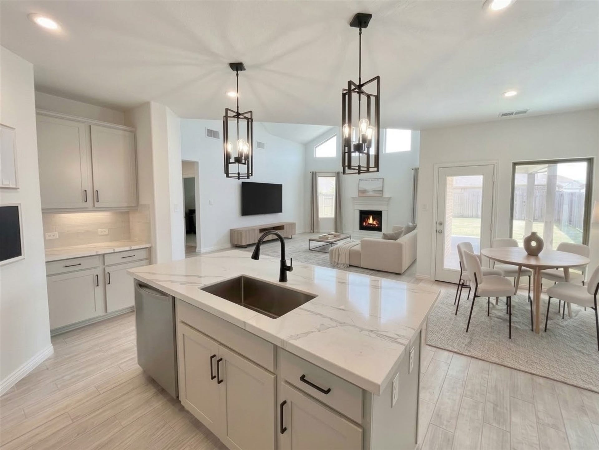8822 SPINNING MILL DRIVE, Missouri City, TX 77459 FROM THE KITCHEN ISLAND, THE OPEN LAYOUT LOOKS INTO THE FAMILY ROOM WITH ITS FIREPLACE AND TALL WINDOWS.