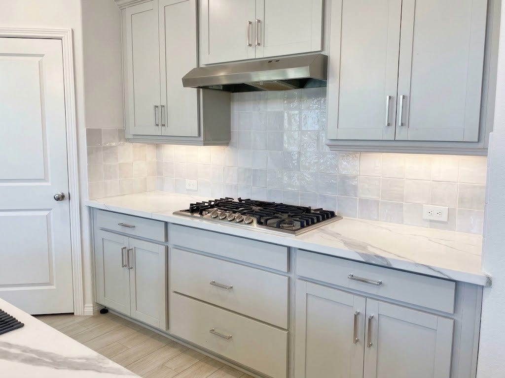8822 SPINNING MILL DRIVE, Missouri City, TX 77459 DEEP POTS/PANS DRAWERS ARE UNDERNEATH A 5-BURNER GAS COOKTOP WITH STAINLESS STEEL VENT HOOD. TILE BACKSPLASH AND CABINET STORAGE ON BOTH SIDES.