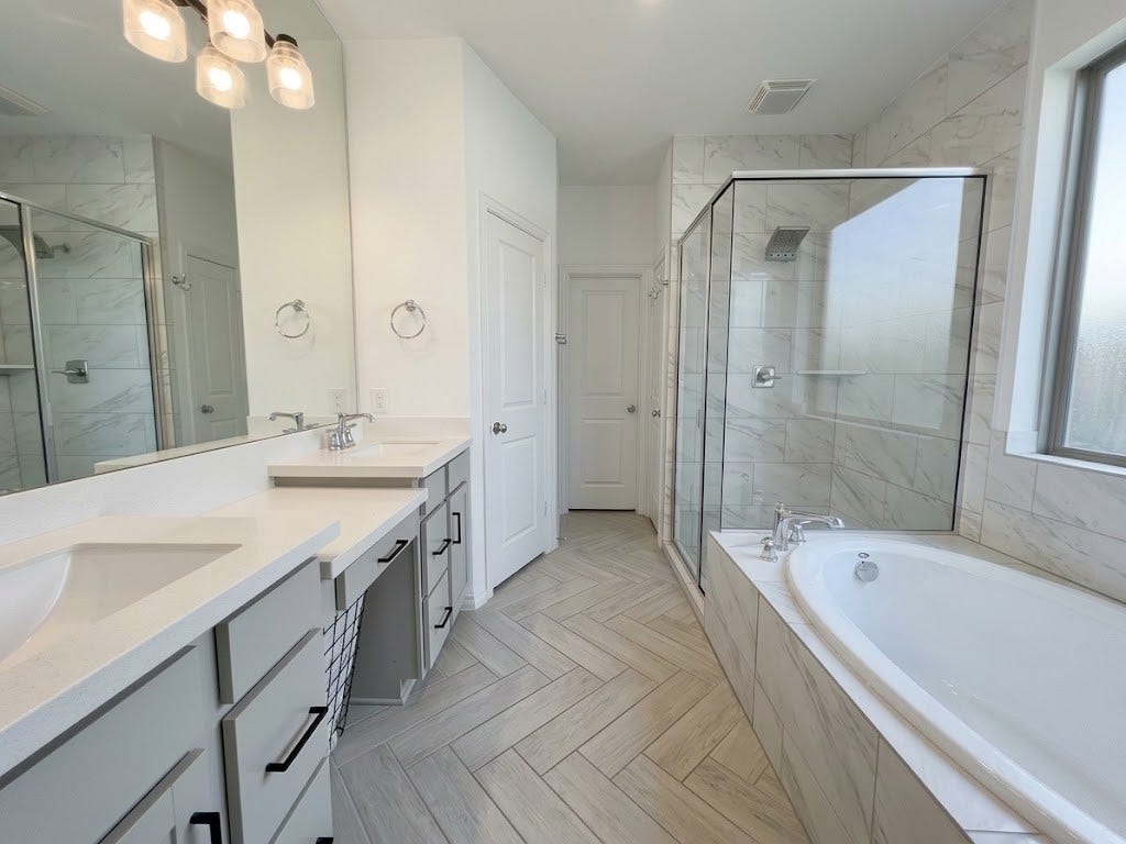 8822 SPINNING MILL DRIVE, Missouri City, TX 77459 THE PRIMARY BATH PAIRS A LONG DOUBLE VANITY WITH A SEPARATE SOAKING TUB AND SHOWER.