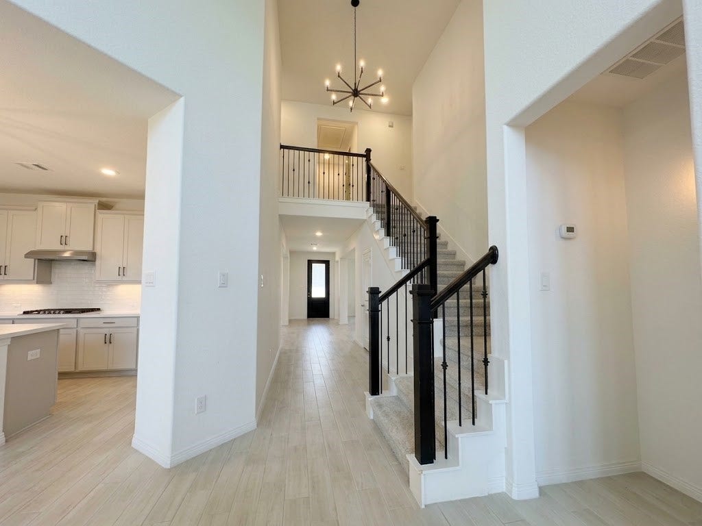8822 SPINNING MILL DRIVE, Missouri City, TX 77459 THE STAIRCASE SITS JUST OFF THE MAIN ENTRY, WITH OPEN SIGHTLINES TOWARD THE KITCHEN.
