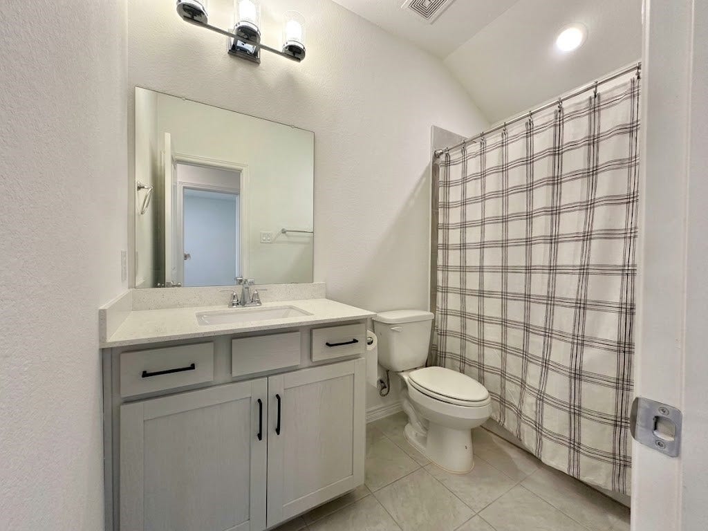 8822 SPINNING MILL DRIVE, Missouri City, TX 77459 A FULL BATH WITH A TUB/SHOWER COMBINATION, SINGLE-SINK VANITY, AND GRAY CABINETRY.