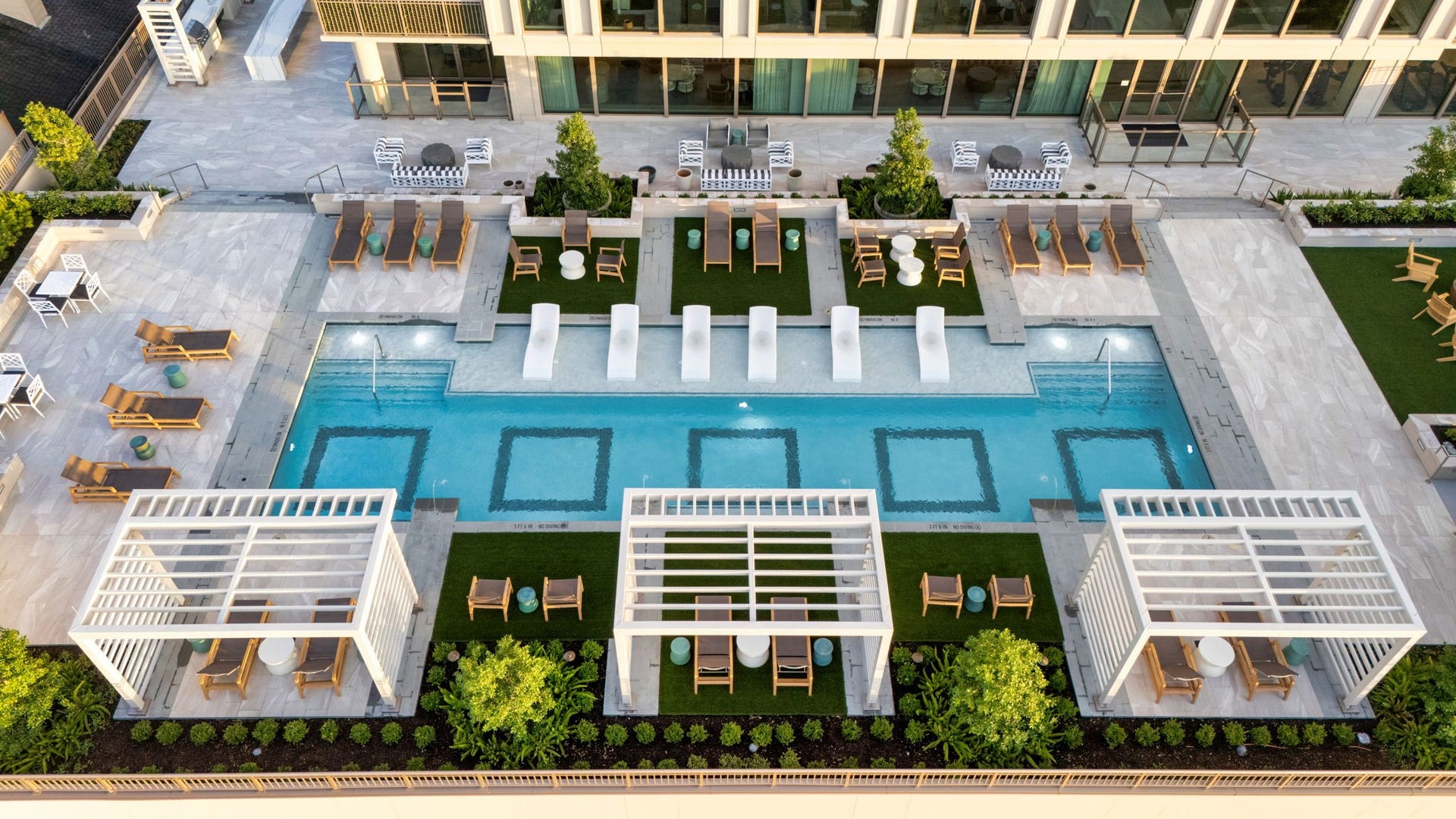 5656 San Felipe Street, Unit 701, Houston, TX 77056 An aerial capturing a stunning bird's-eye view of the pool area, showcasing the symmetry of custom decking and the flawless of the geometric design.