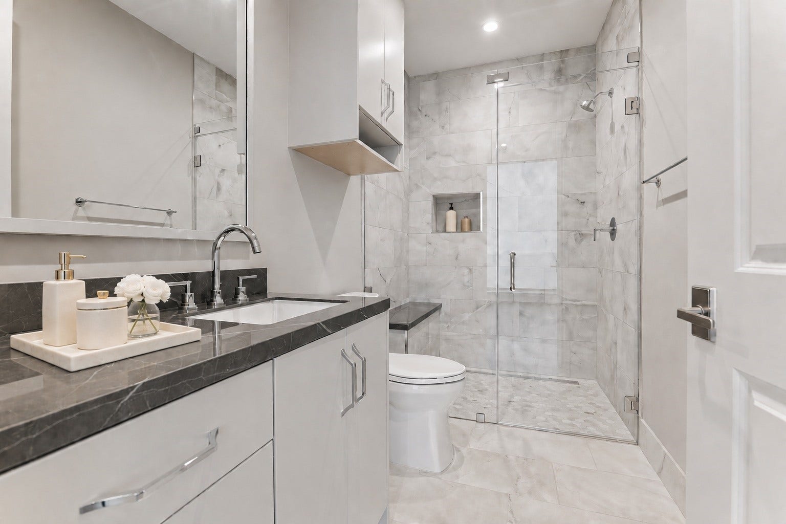 5656 San Felipe Street, Unit 701, Houston, TX 77056 Luxury en-suite guest bath with custom built-ins, glass enclosed walk-in shower with shower seat, custom built-in cabinet above the toilet and elegant quartz counter-top