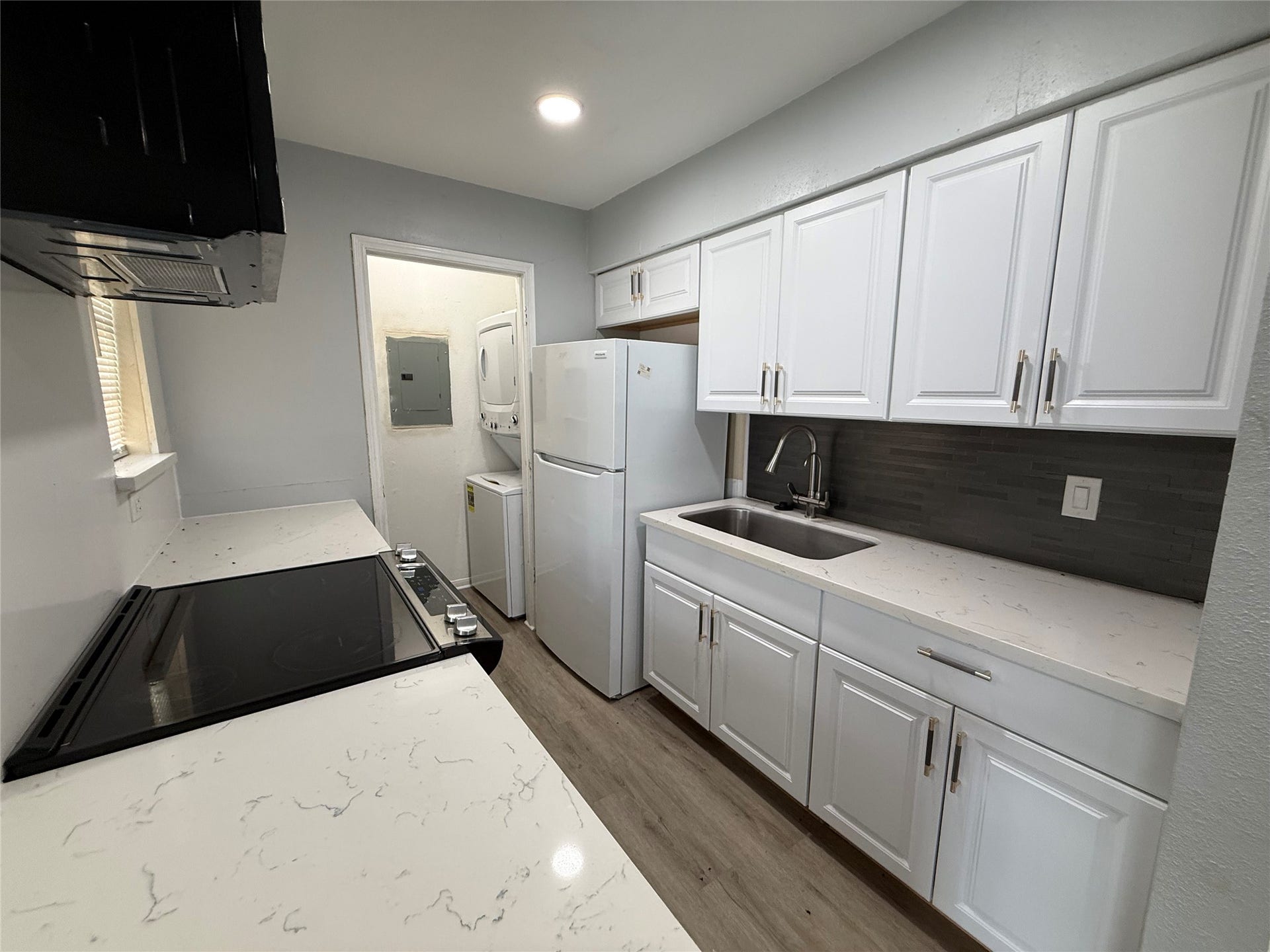 9550 Deering Drive, #210, Houston, TX 77036 Kitchen has been updated with quartz countertops and new range and microwave. You can see the laundry space tucked away behind the kitchen.