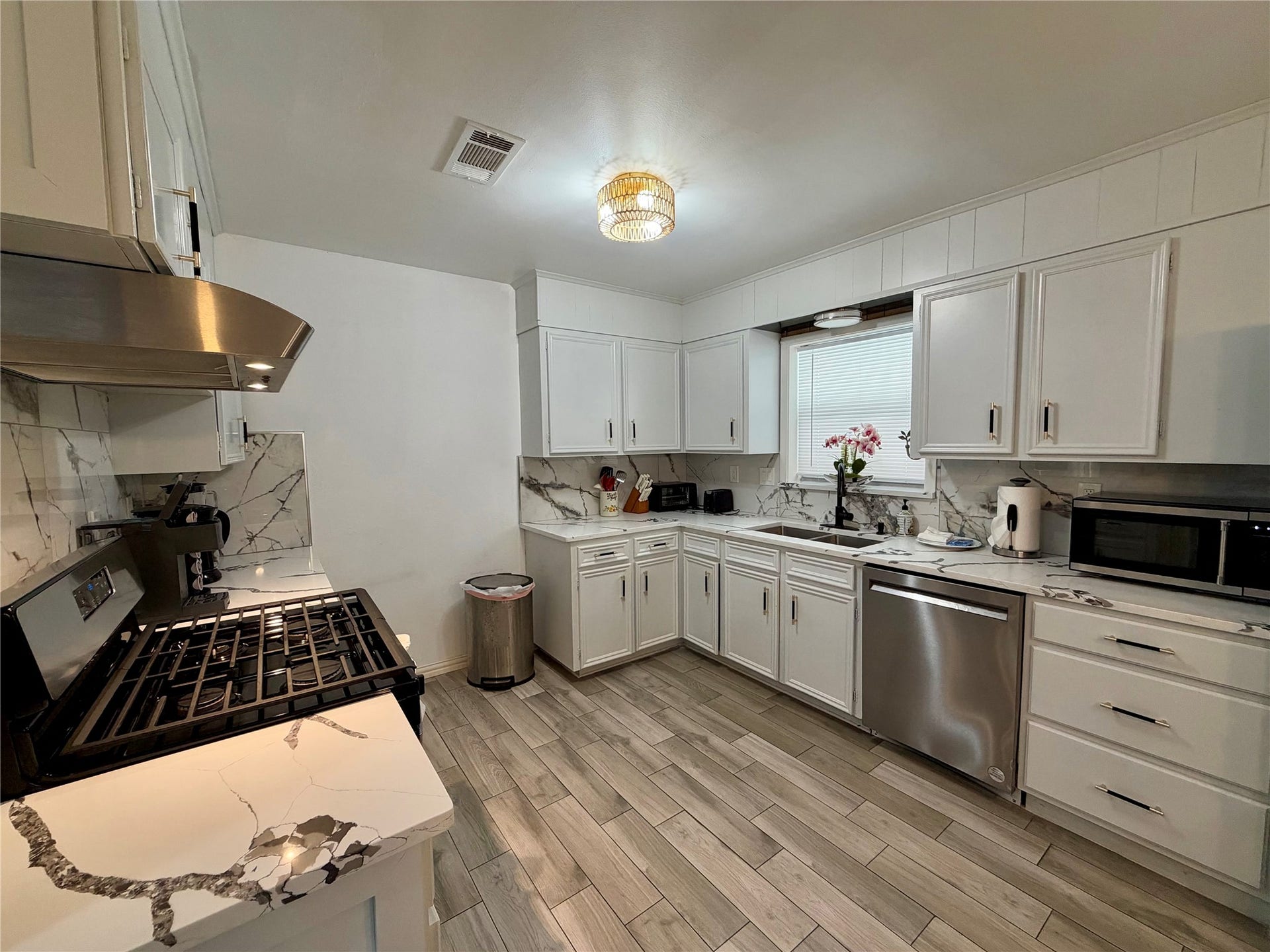 5420 Avenue O, Galveston, TX 77551 Open kitchen has been updated with freshly painted cabinets, newer appliances, and beautiful tile flooring.