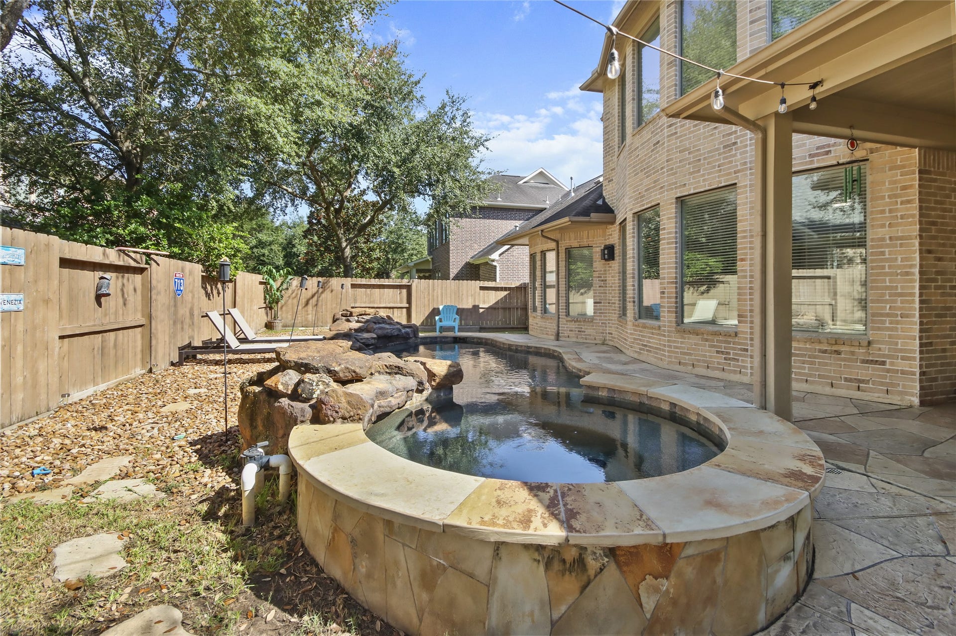 27906 Iberville Glen Dr, Katy, TX 77494 Unwind in your private backyard oasis featuring a beautiful stone- accented jacuzzi with a cascading waterfall, perfect for relaxing after a long day.