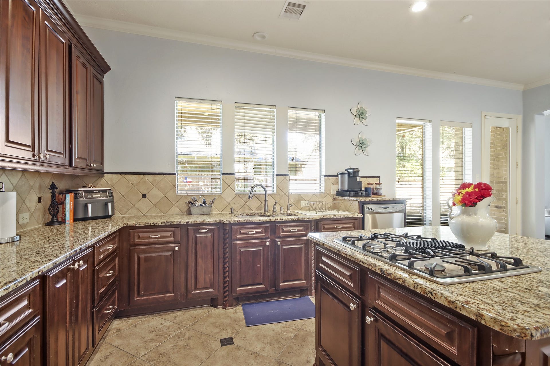 27906 Iberville Glen Dr, Katy, TX 77494 Beautiful kitchen features elegant dark wood cabinetry. Granite countertops, and a central island with seating.
