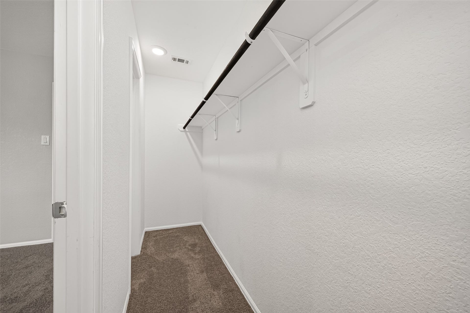 19494 Rosali Meadow Drive, New Caney, TX 77357 A large walk-in closet with ample hanging space and soft carpet flooring, perfect for organizing your wardrobe.