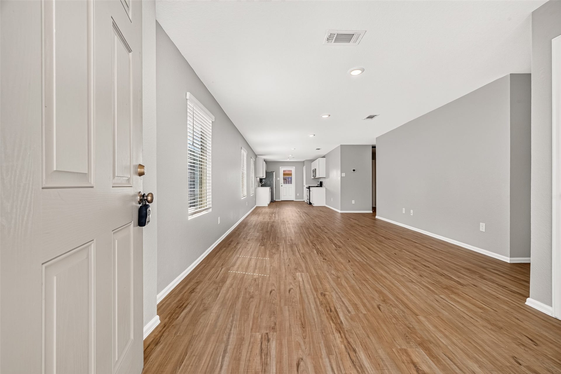 19494 Rosali Meadow Drive, New Caney, TX 77357 Spacious and inviting open-concept living area with warm wood flooring and abundant natural light, perfect for entertaining or relaxing.