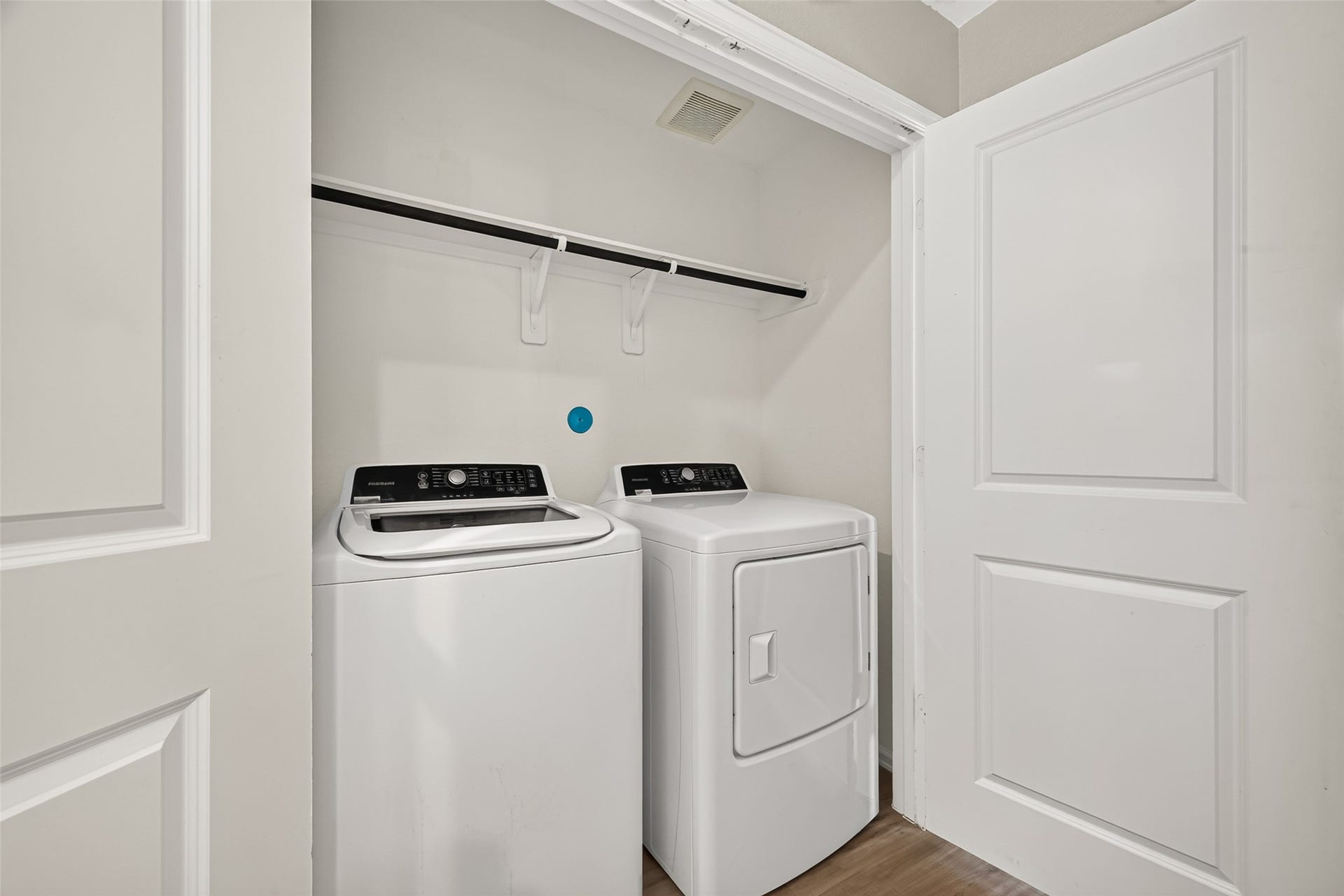 19494 Rosali Meadow Drive, New Caney, TX 77357 Convenient laundry closet with modern washer and dryer, complete with overhead shelving for extra storage.