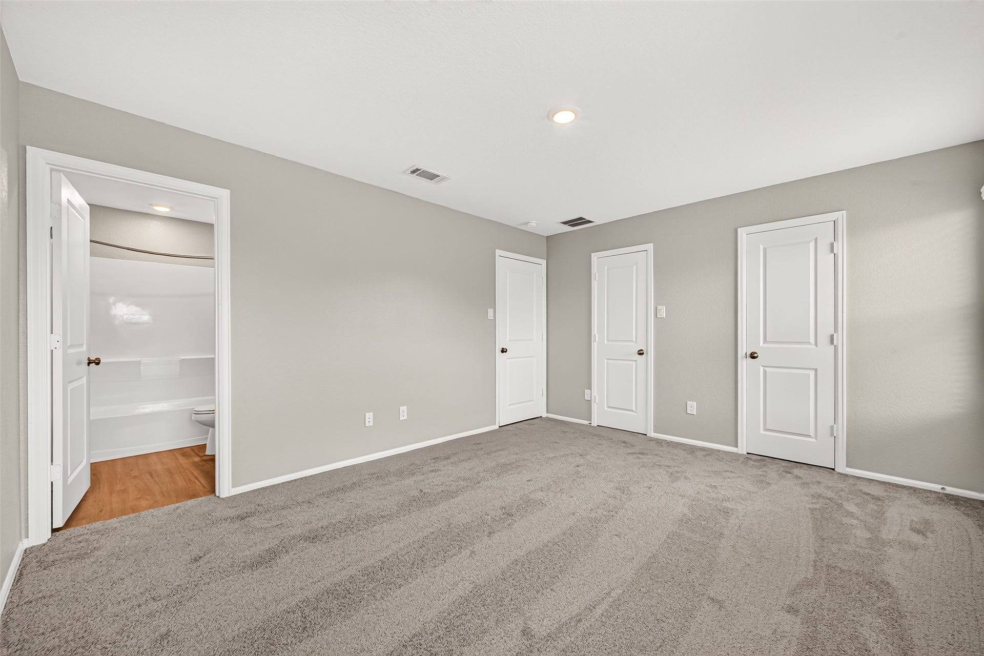 19494 Rosali Meadow Drive, New Caney, TX 77357 Spacious bedroom with plush carpeting, neutral walls, and ample closet space, featuring an en-suite bathroom for added convenience.
