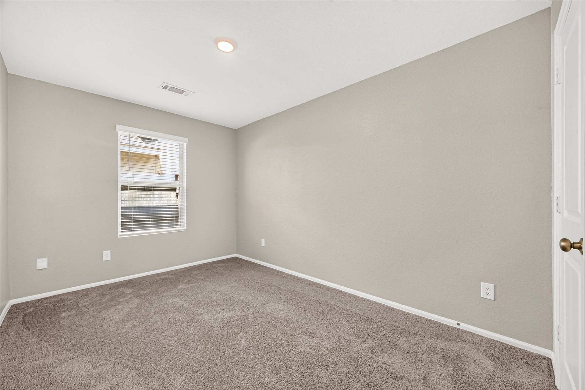 19494 Rosali Meadow Drive, New Caney, TX 77357 Cozy bedroom with neutral walls, soft carpeting, and a bright window allowing ample natural light.