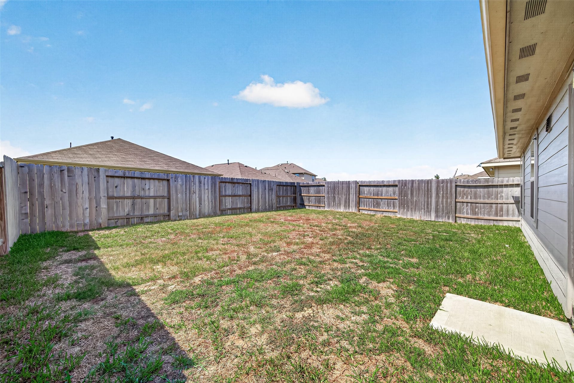 19494 Rosali Meadow Drive, New Caney, TX 77357 Spacious fenced backyard with ample room for outdoor activities and potential for landscaping.