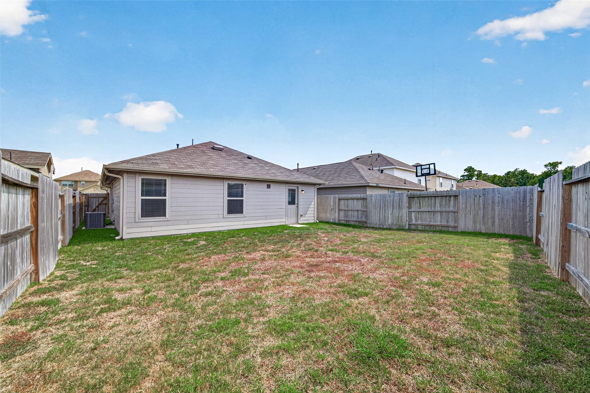 19494 Rosali Meadow Drive, New Caney, TX 77357 Spacious backyard with a privacy fence, perfect for outdoor activities and relaxation.
