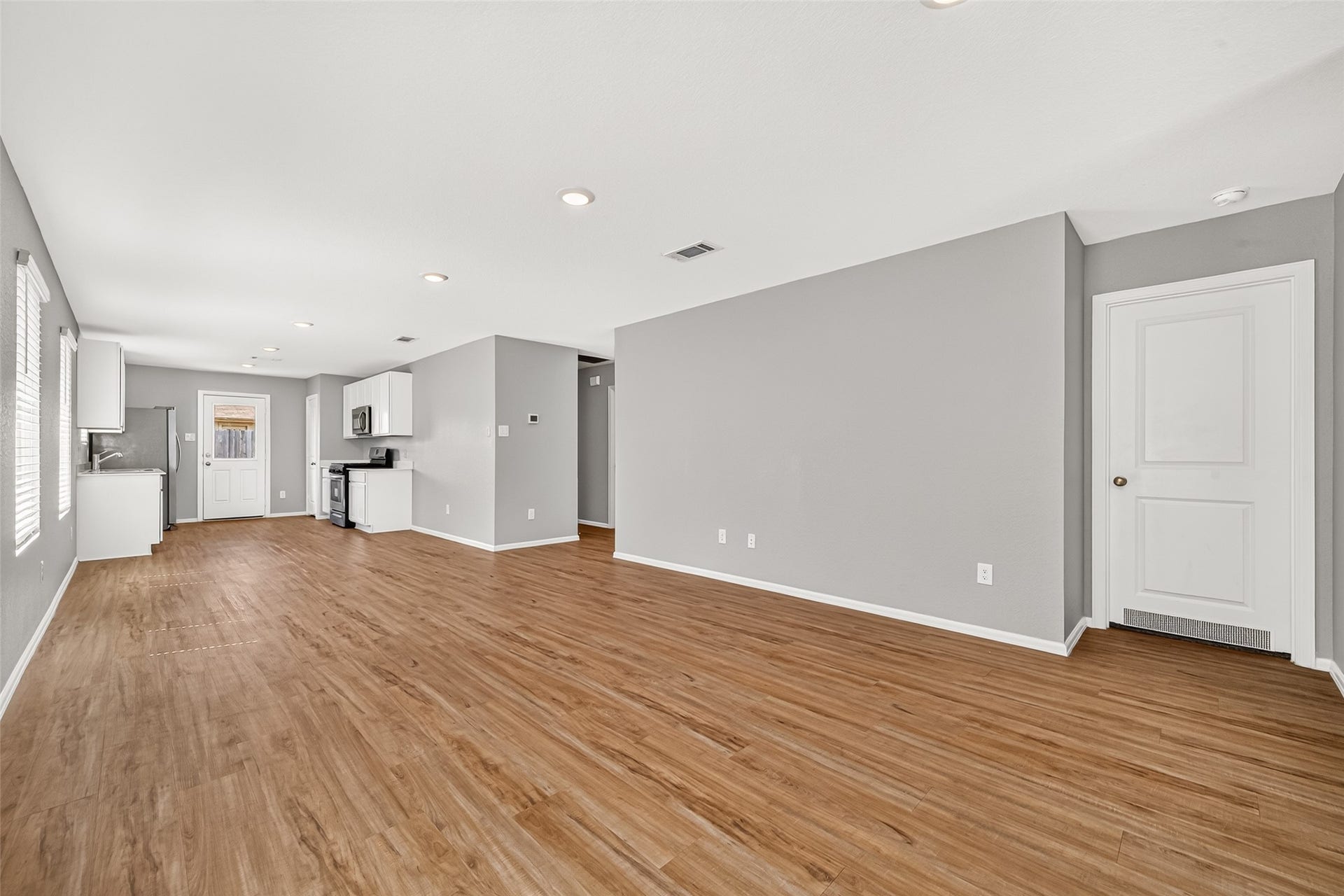 19494 Rosali Meadow Drive, New Caney, TX 77357 Nice open-concept living area with sleek hardwood floors and modern kitchen featuring stainless steel appliances and ample natural light.