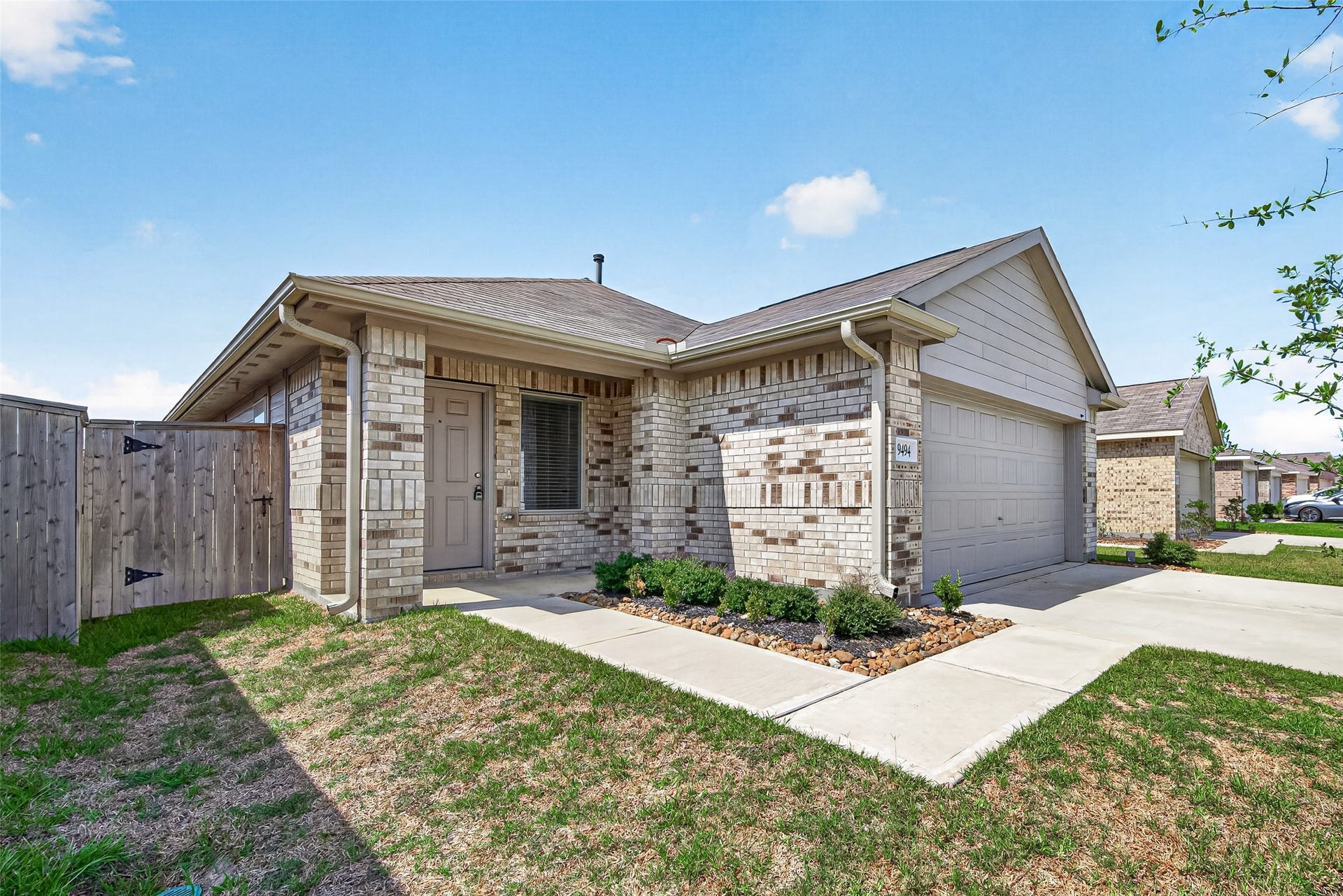19494 Rosali Meadow Drive, New Caney, TX 77357 Charming single-story home with a brick exterior, cozy front porch, and attached garage, set in a well-maintained neighborhood.
