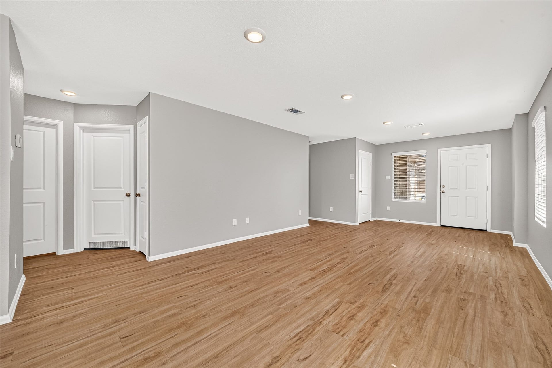19494 Rosali Meadow Drive, New Caney, TX 77357 Spacious living area with warm wood flooring, recessed lighting, and neutral gray walls, offering a modern and inviting atmosphere.